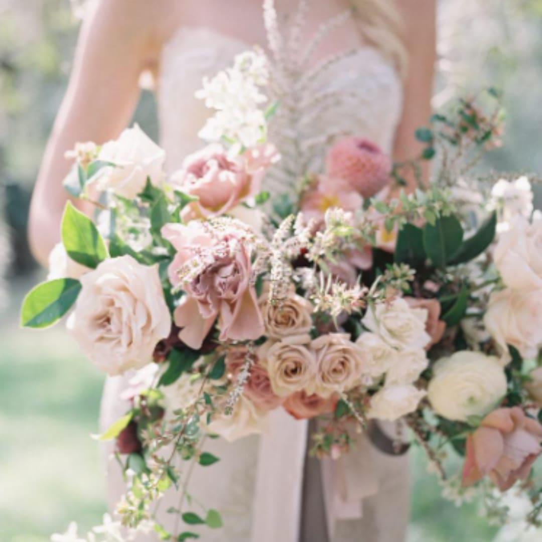 Bride holding a pastel bouquet of roses and mixed blooms