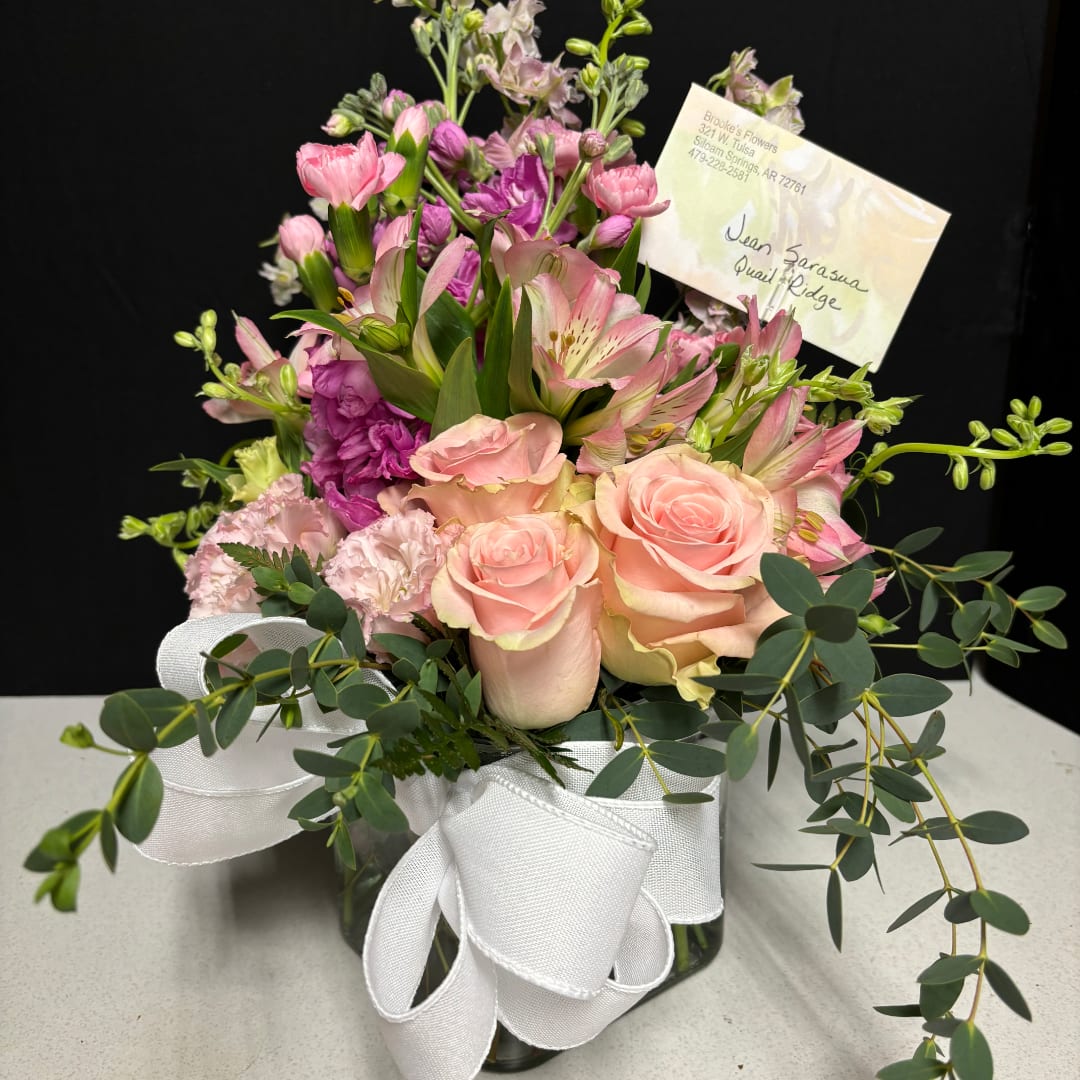 Pink and peach mixed bouquet in a glass vase with a white ribbon