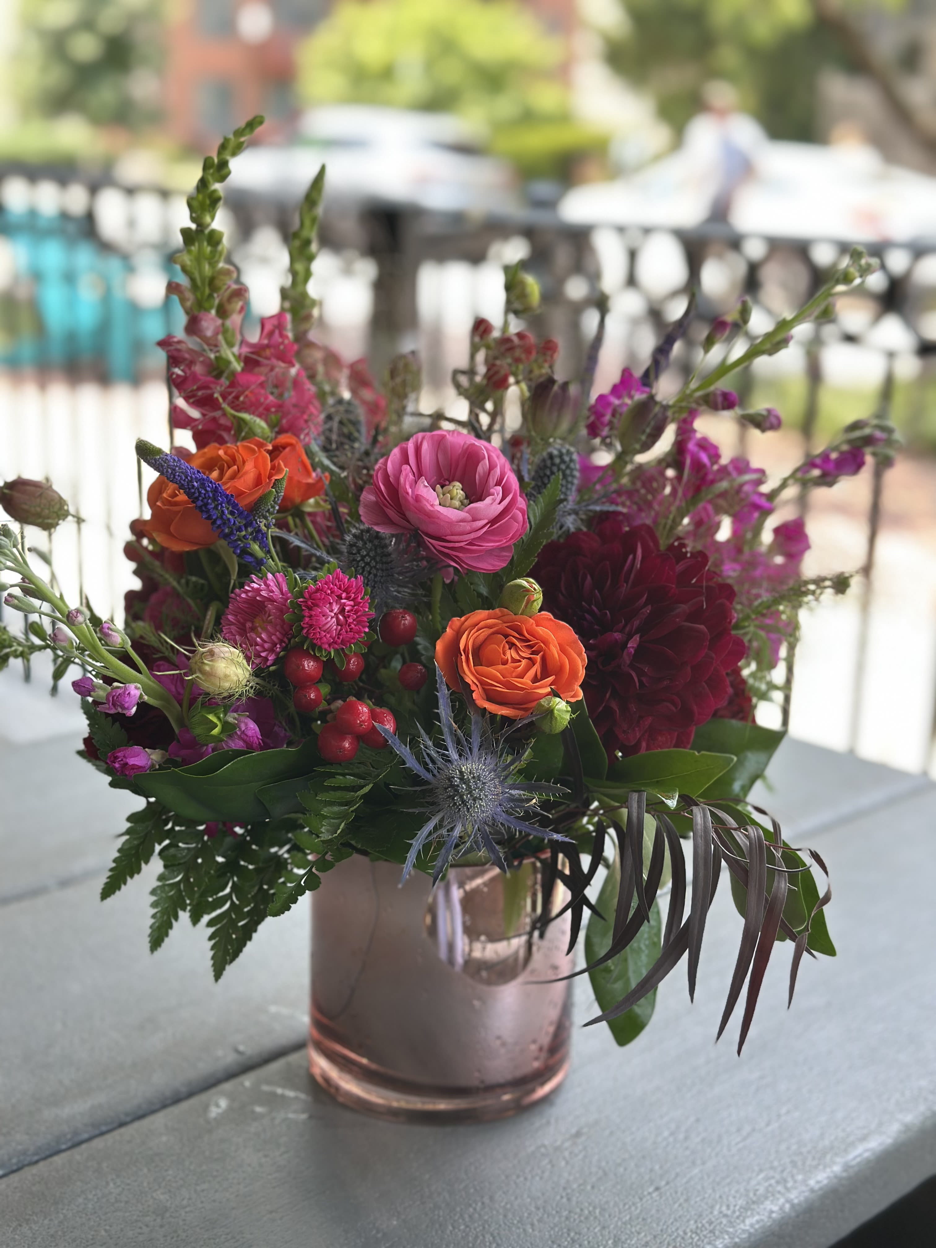 Moonrise Kingdom - **For a limited time only** This arrangement is full of lush ranunculus, roses, dahlias, and seasonal accents bloom together in a romantic palette of raspberry, plum, coral, and violet. This Moonrise Kingdom is a great arrangement for almost any occasion from romantic gestures to just because.