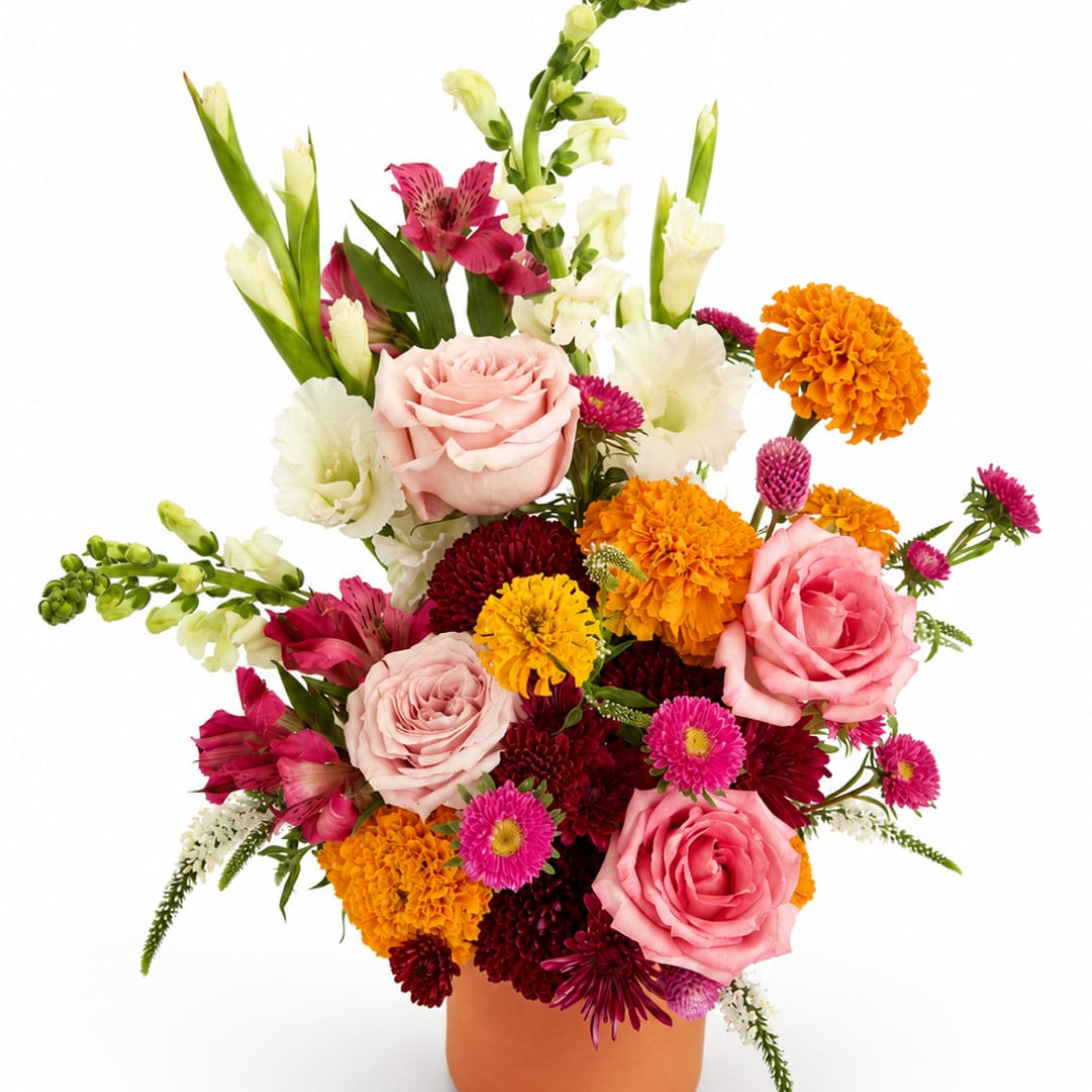 Mixed bouquet of pink roses, orange marigolds, and white blooms in a terracotta vase