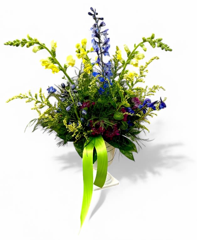 Tall mixed flower arrangement with blue, yellow, and burgundy blooms in a vase