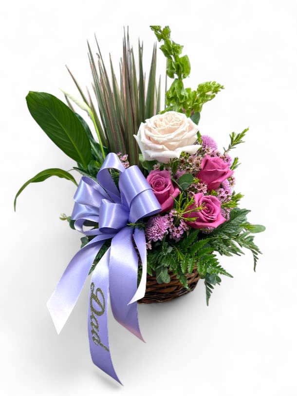 Basket arrangement of pink and white roses with a lavender ribbon
