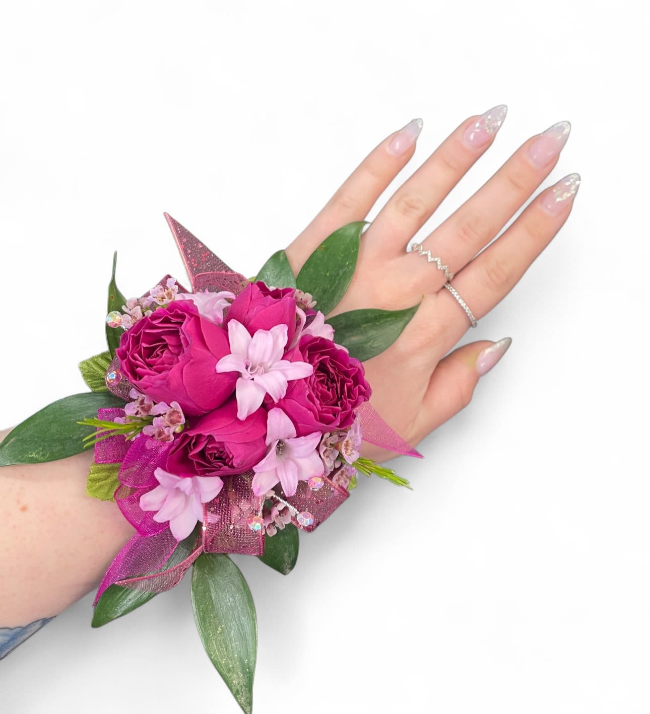 Pink rose wrist corsage with ribbon and greenery