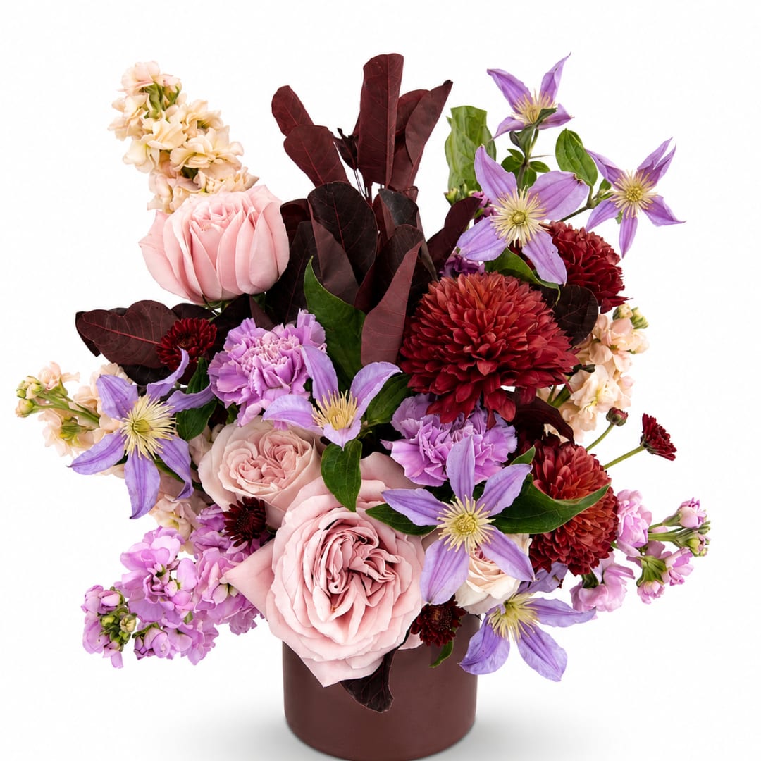 Pink roses and purple flowers arranged in a brown vase