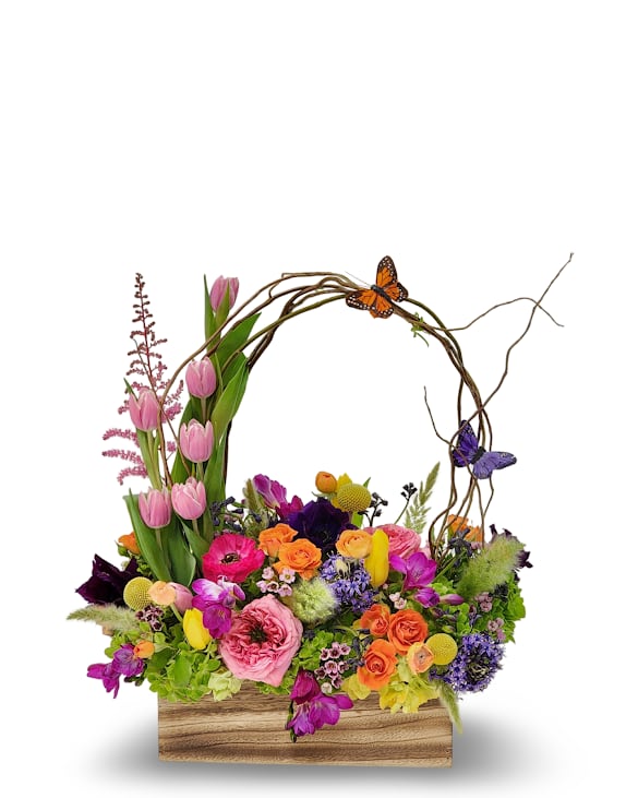 Colorful mixed flower arrangement in a wooden box with butterfly accents