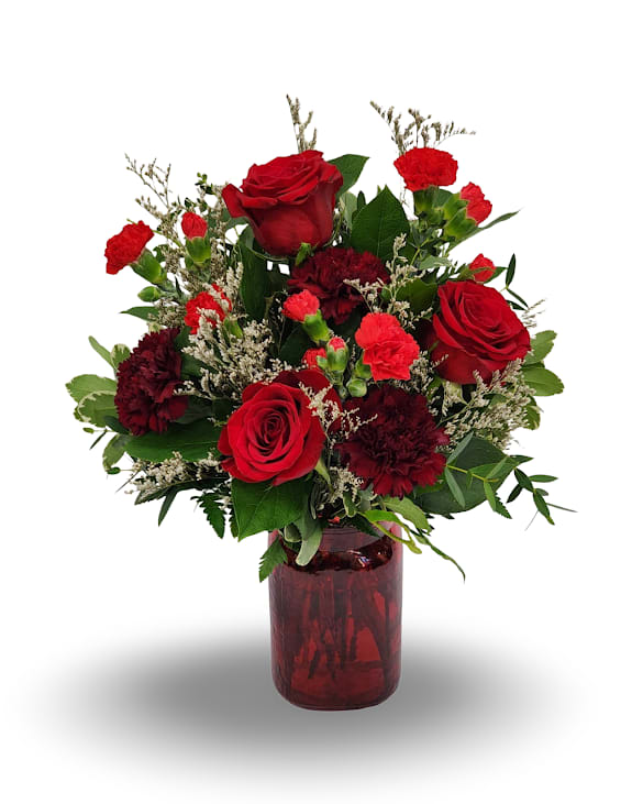 Red roses and carnations in a red glass vase