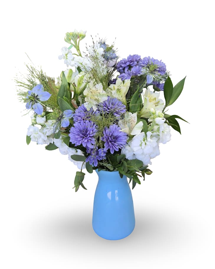 Purple and white mixed bouquet in a blue vase