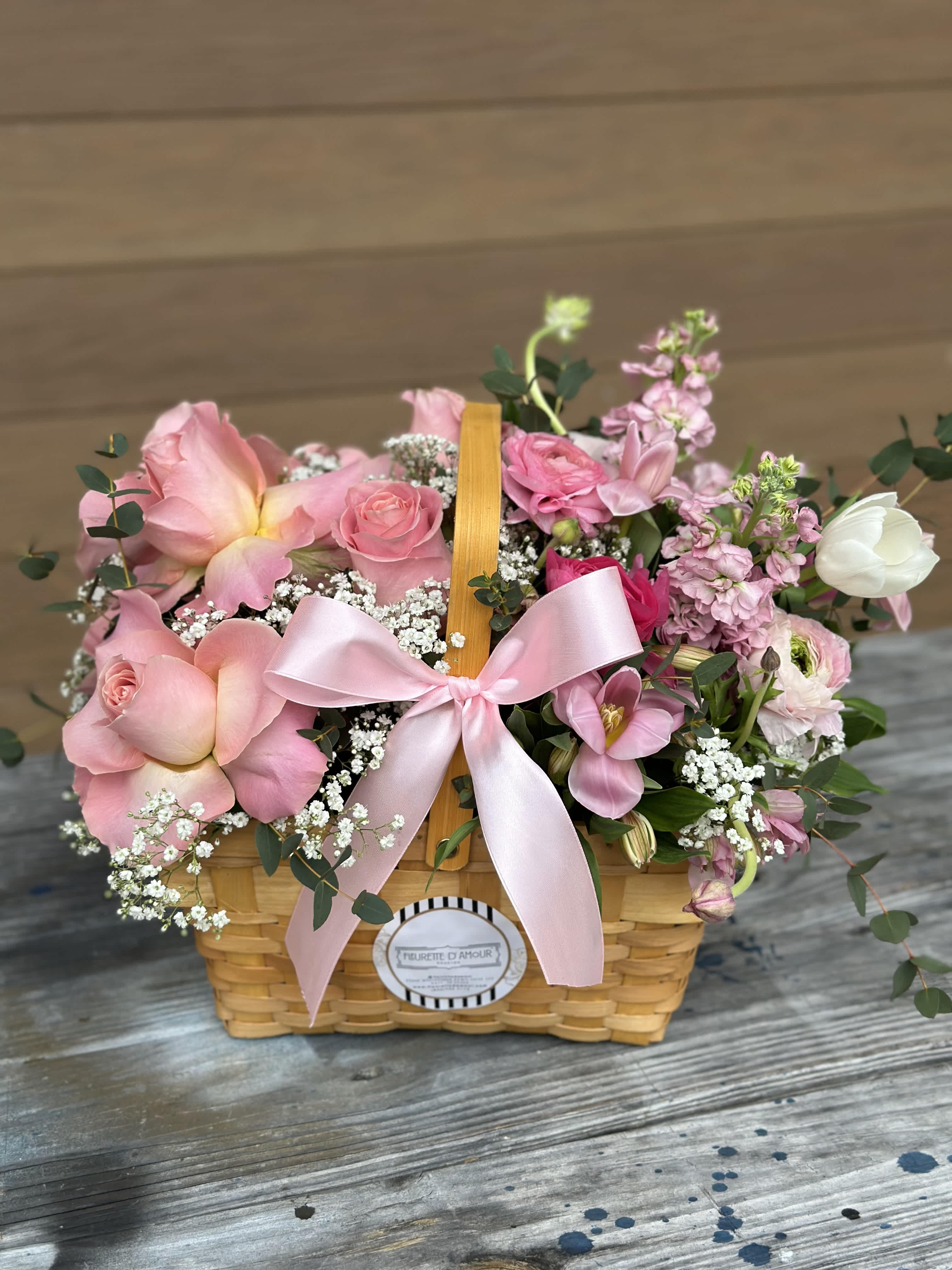 Pink floral basket with roses and a ribbon bow
