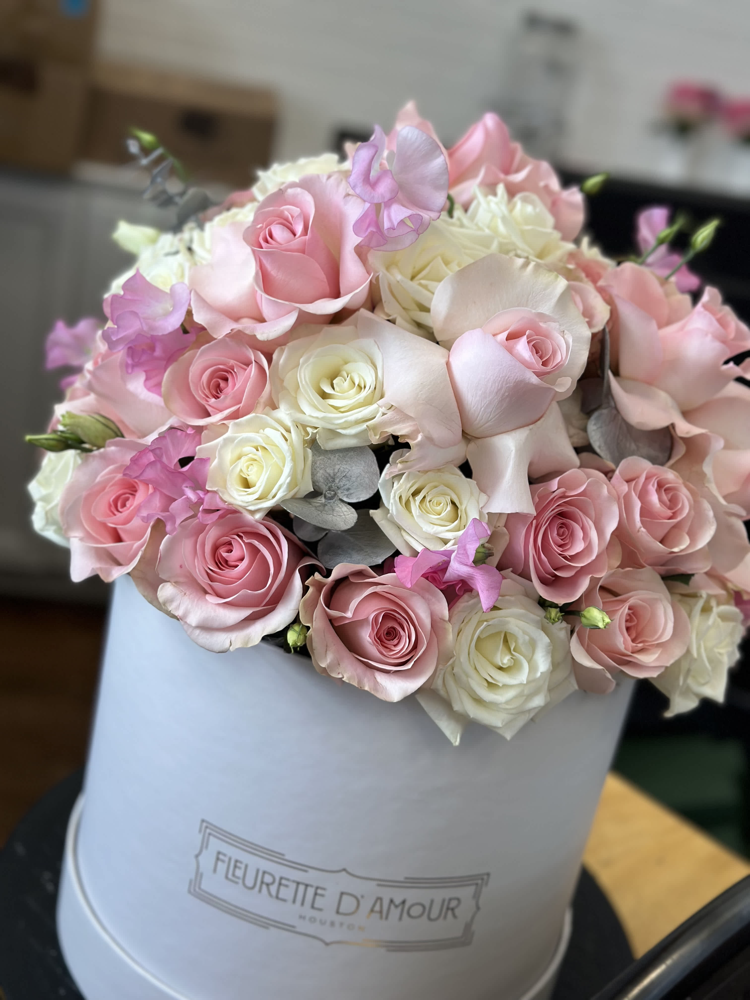 Pink and white rose bouquet in a white hat box