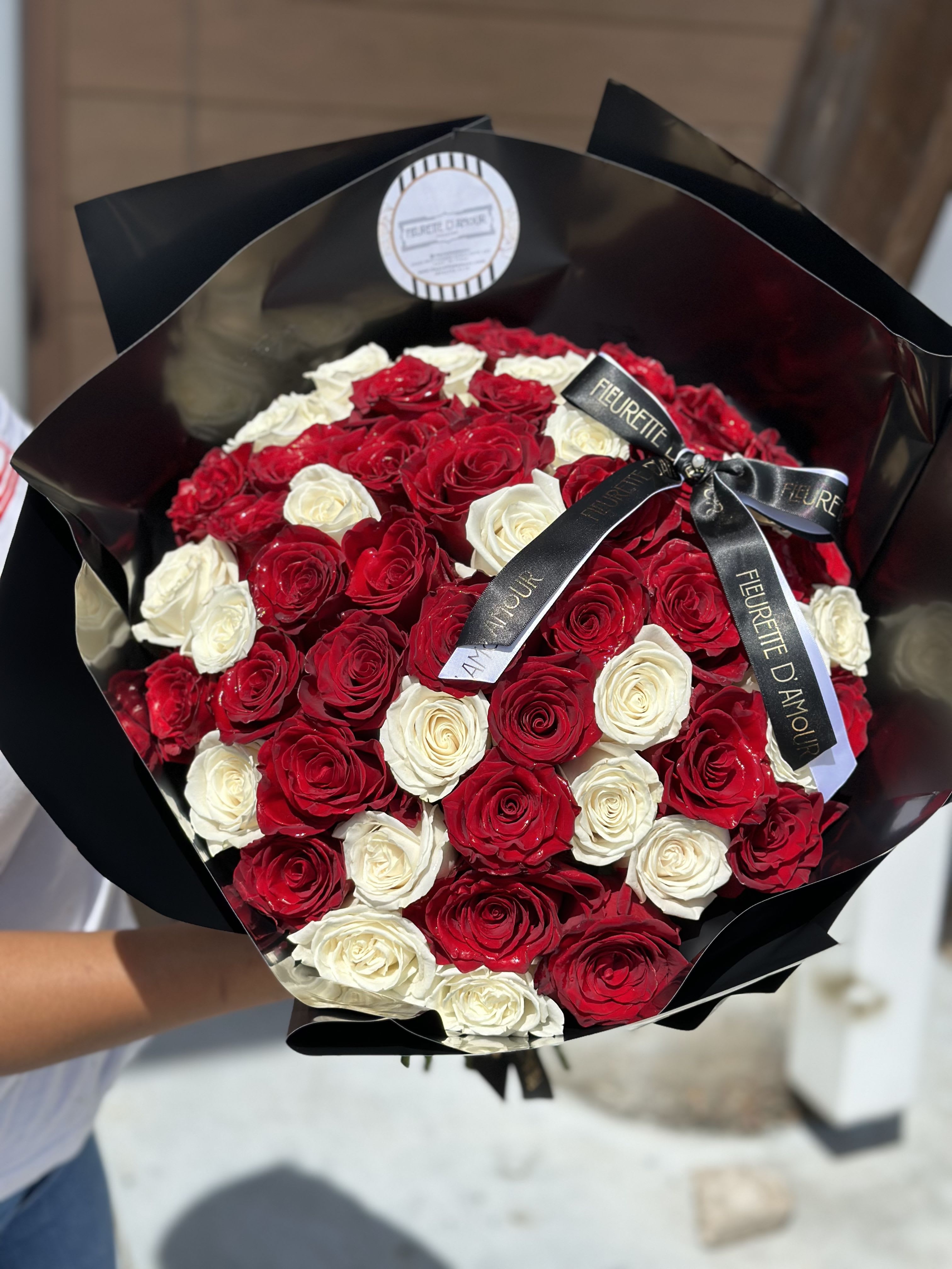 Bouquet of red and white roses wrapped in black paper