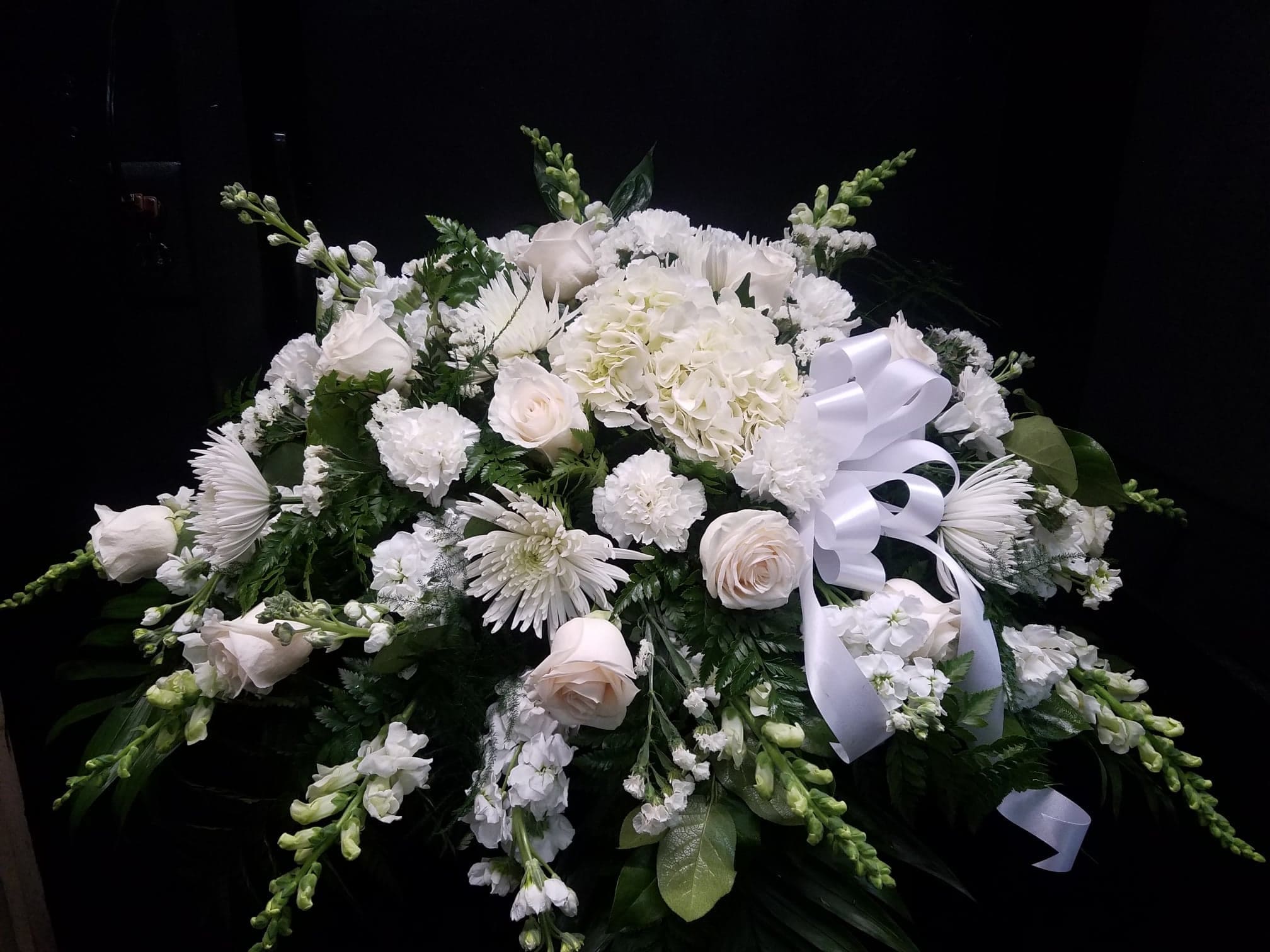 All White Casket Spray - Show purity of love with a mix of all-white flowers that’s as gentle and pure as a cloud. Accented with a mix of greenery, fragrant white flowers create a lovely and traditional casket spray.
