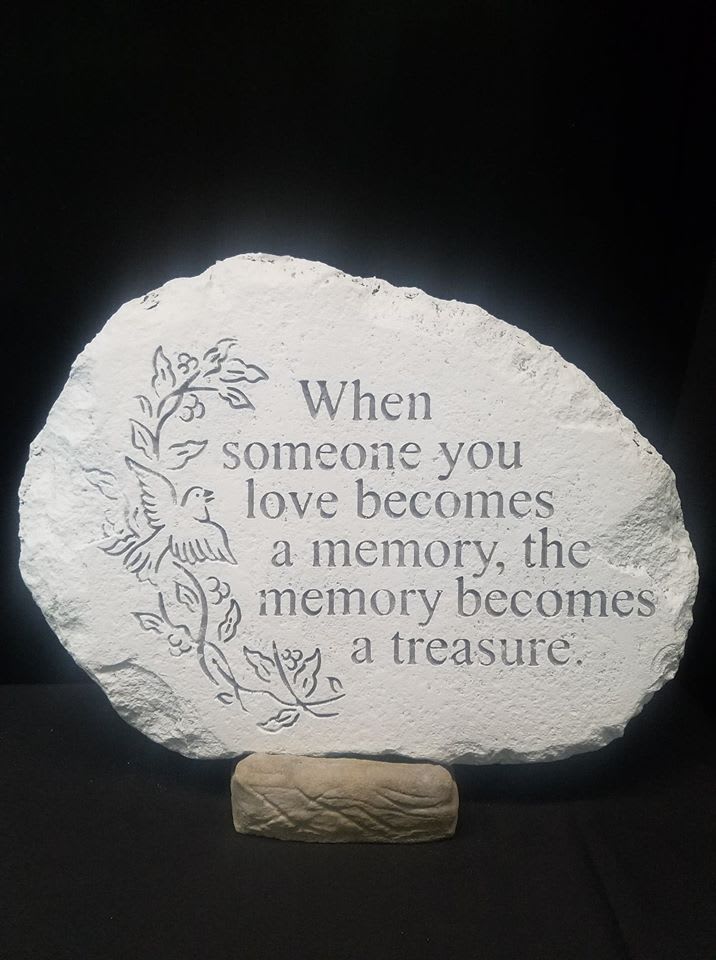 Memorial stone with engraved quote and dove design on a stand