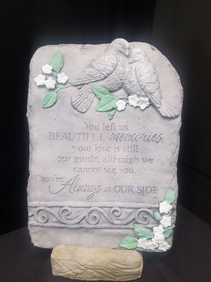 Stone memorial plaque with two doves and floral accents