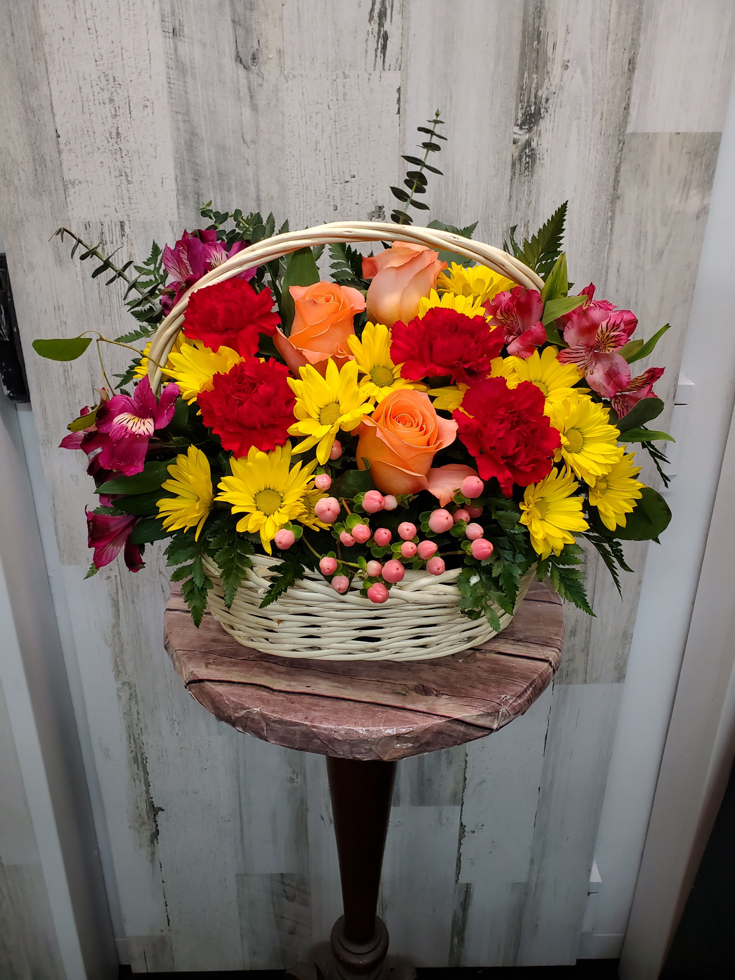  Joy - Know anyone who would really appreciate a basketful of joy right now? Send love and flowers with this beautiful array of fantastic fall flowers.  The basket overflows with orange roses and spray roses, maroon carnations, purple alstroemeria, burgundy button spray chrysanthemums, yarrow and even a bunch of grapes (not real, of course)!  Approximately 13 3/4" W x 11 3/4" H  Orientation: All-Around  As Shown : T173-3A Deluxe : T173-3B Premium : T173-3C