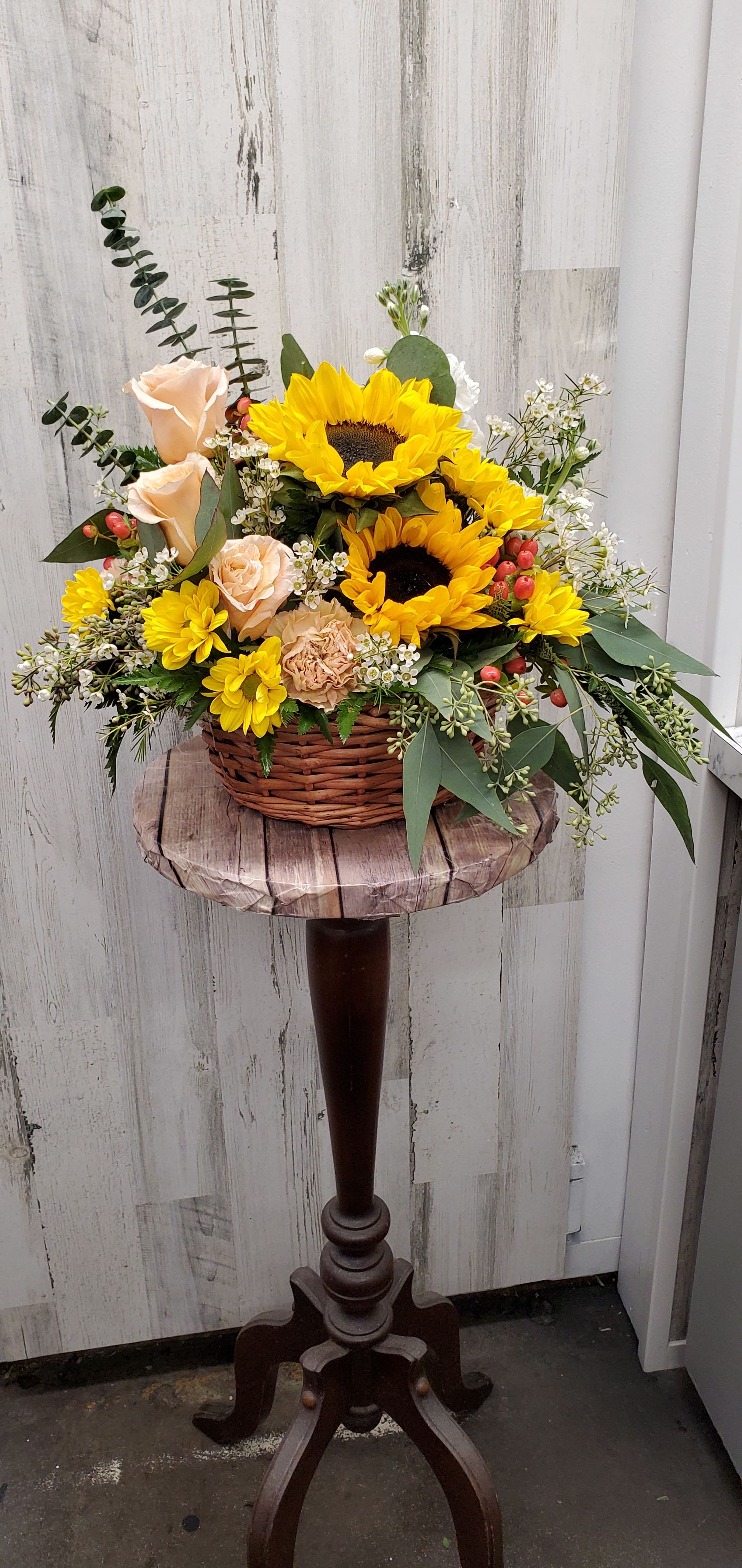 Sunny - Life will be a picnic for whoever's lucky enough to receive this gift. It's a lovely basket that's chock full of fabulous flowers.  Peach spray roses, large yellow sunflowers, miniature green hydrangea, purple stock, hot pink matsumoto asters and more are delightfully arranged in a charming wicker basket.     