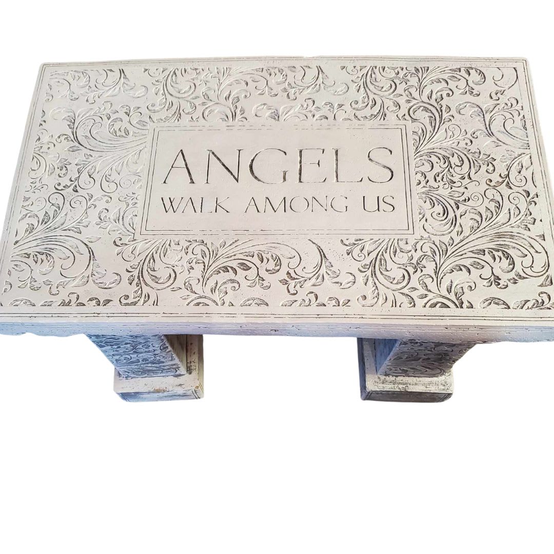 Decorative wooden bench with the words "ANGELS WALK AMONG US"