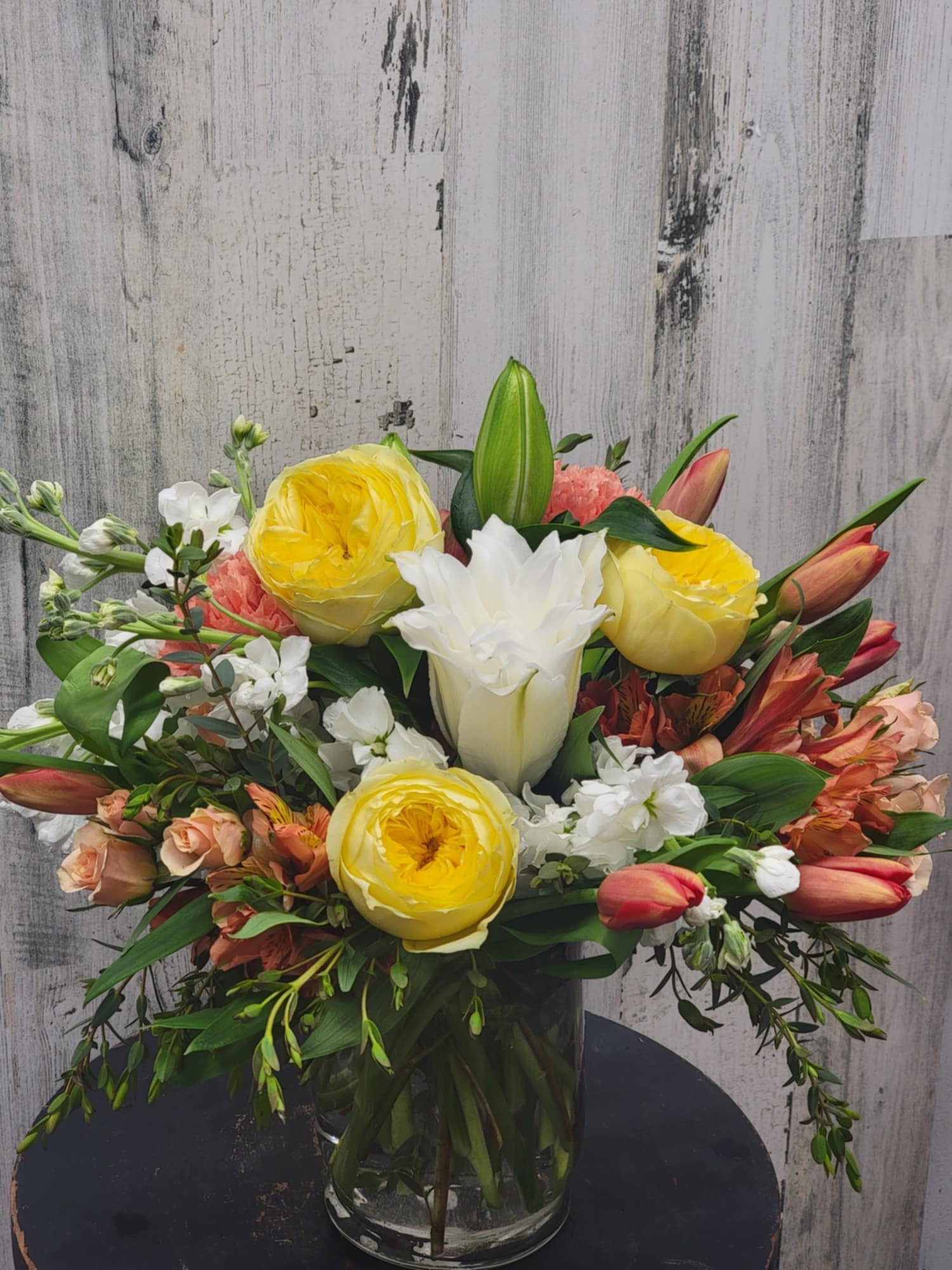 Mixed bouquet of yellow and white flowers in a glass vase