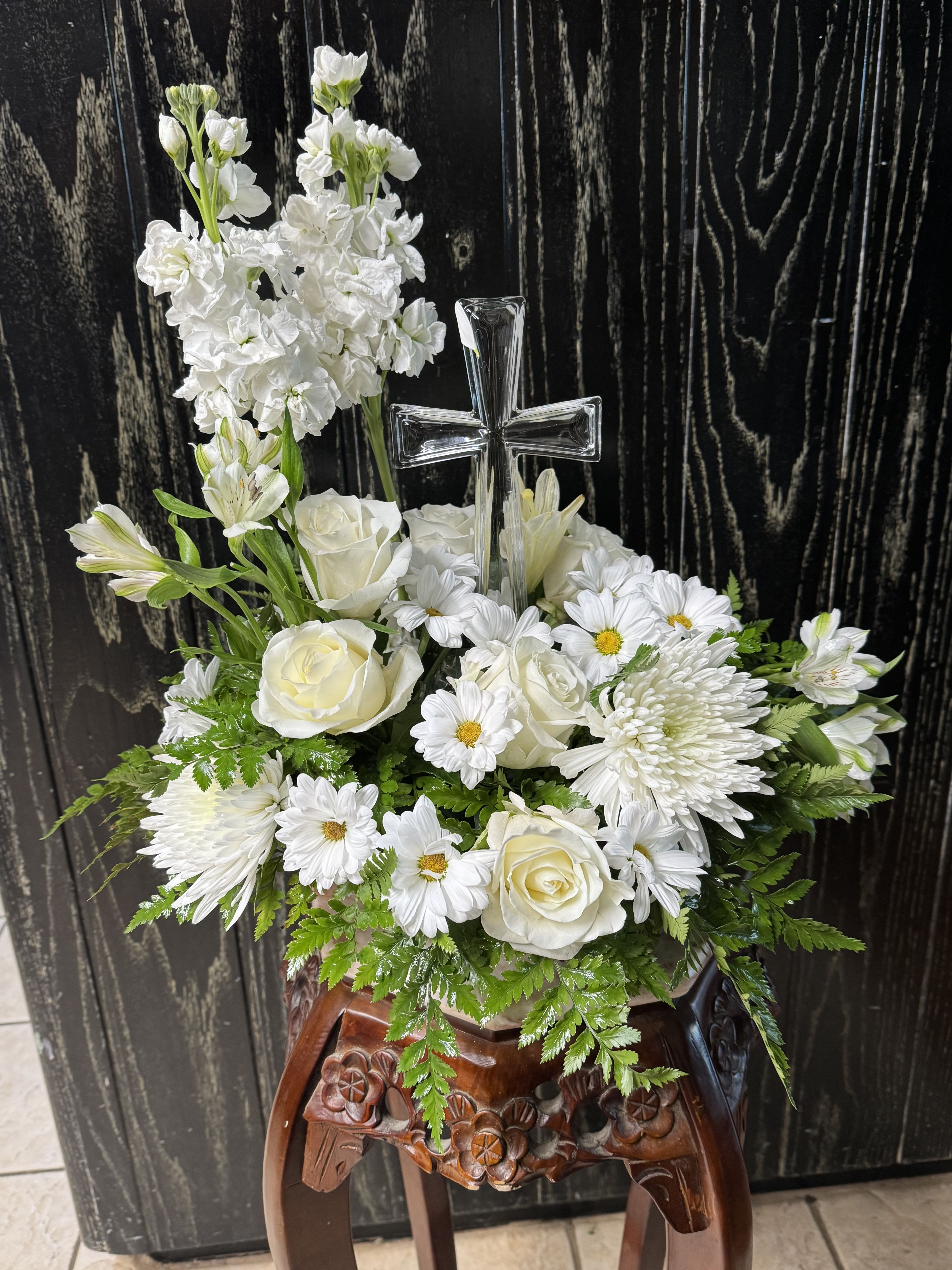 White floral arrangement with a clear cross centerpiece