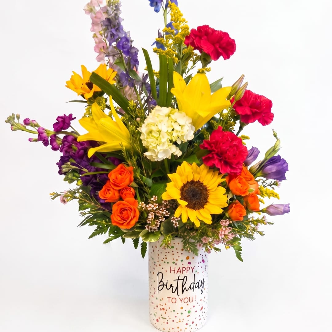 Mixed bouquet in a birthday vase with sunflowers, roses, lilies, and carnations