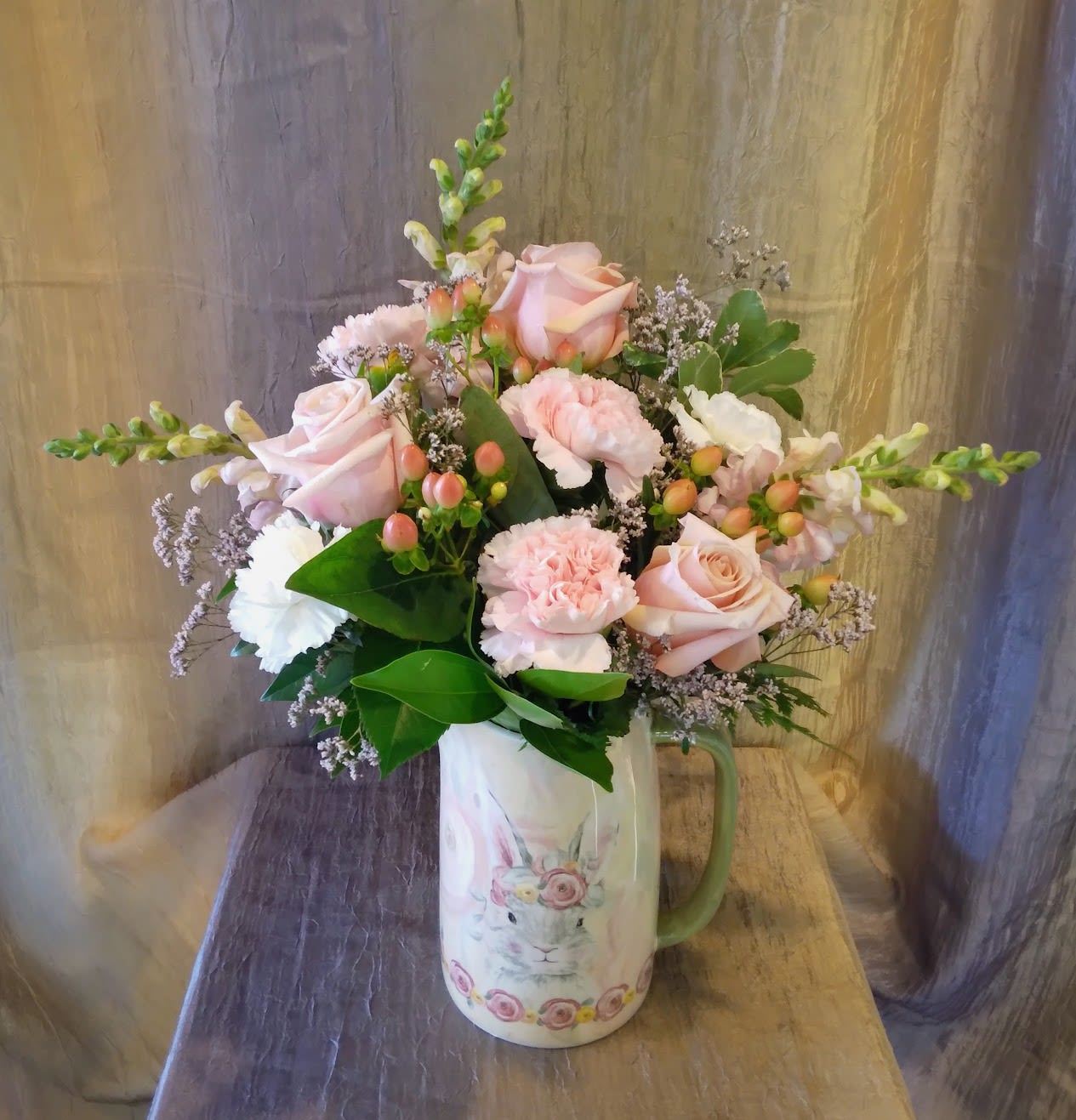 Pink roses and carnations in a rabbit-print pitcher vase