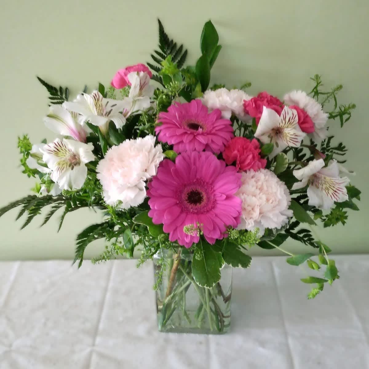 Pink gerberas and white alstroemeria in a clear glass vase