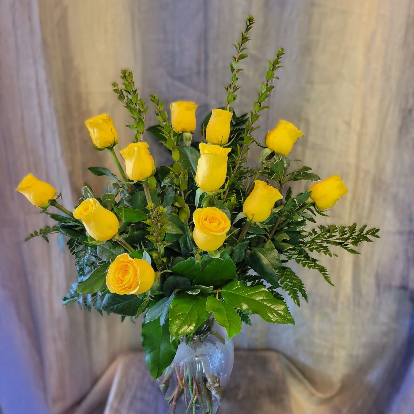 Bodacious Yellow Roses (12) ~ Flower A day - Yellow roses, which symbolize friendship, are the perfect gift to show you care. This bouquet contains 12 yellow roses and fresh foliage in a vase. Yellow Roses will make a beautiful birthday or just because gift for that special friend.