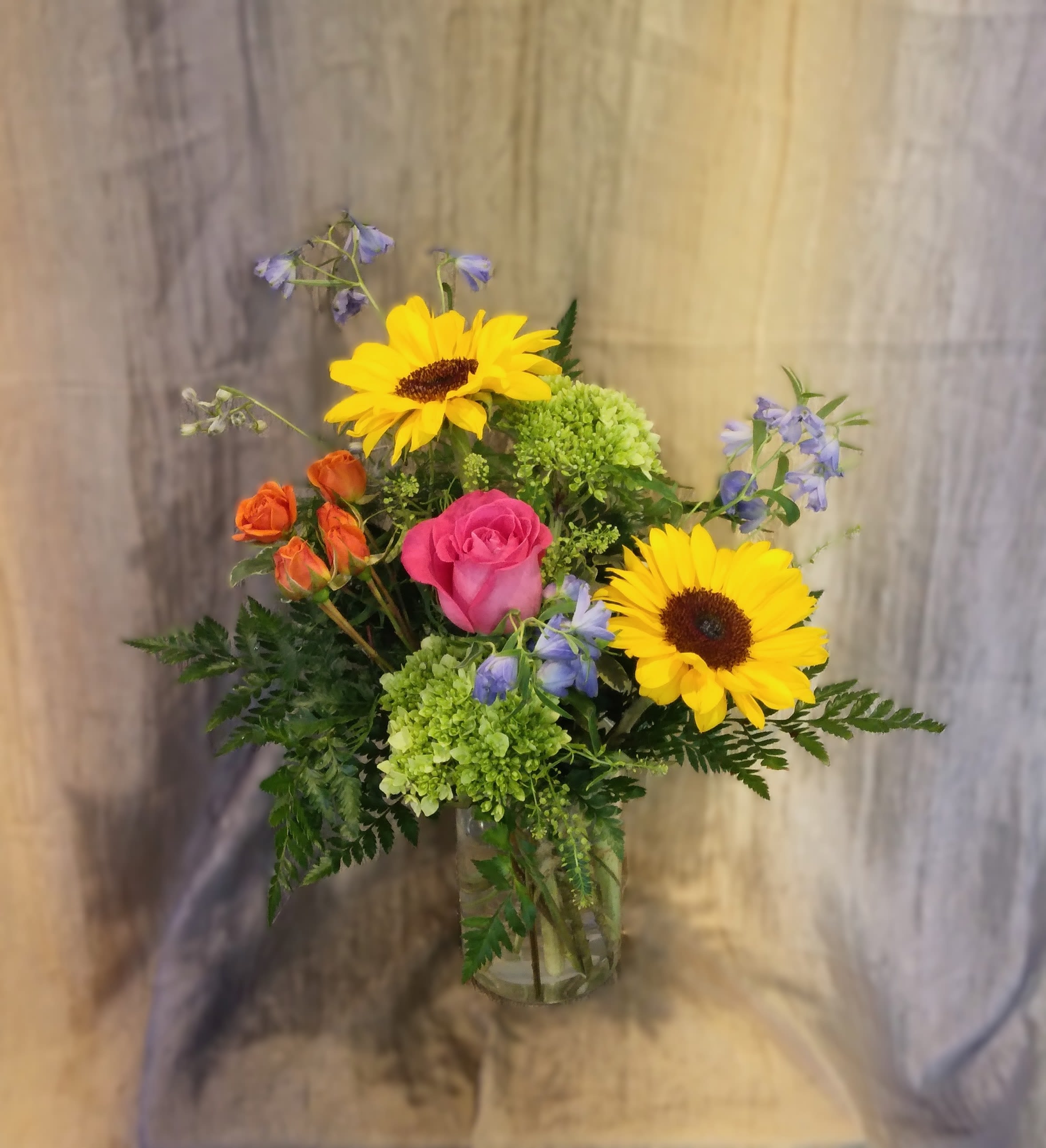 A Brighter Love ~ Flower A Day - This bright and colorful arrangement brings brighter hues to your recipient's eye. Sure to bring a smile to any face, send 'A Brighter Love' to the important people in your life. COLORS MAY VARY