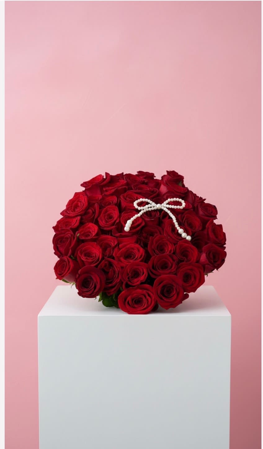 Explore Buchon  - Deep red roses shapes this romantic Buchon style arrangement, perfect as an anniversary gift or a Valentine's Day bouquet for the person you love. The rich, velvety red rose blooms reads as timeless devotion; a small white beaded bow tucked near the top center brings a refined, contrasting highlight that makes the red pop.  A gift that says "I'm thinking of you" with confident elegance. Colors are strictly red with a white beaded accent ; care is simple-keep in fresh water, out of direct sun, and trim stems periodically to preserve the dome's lush look.