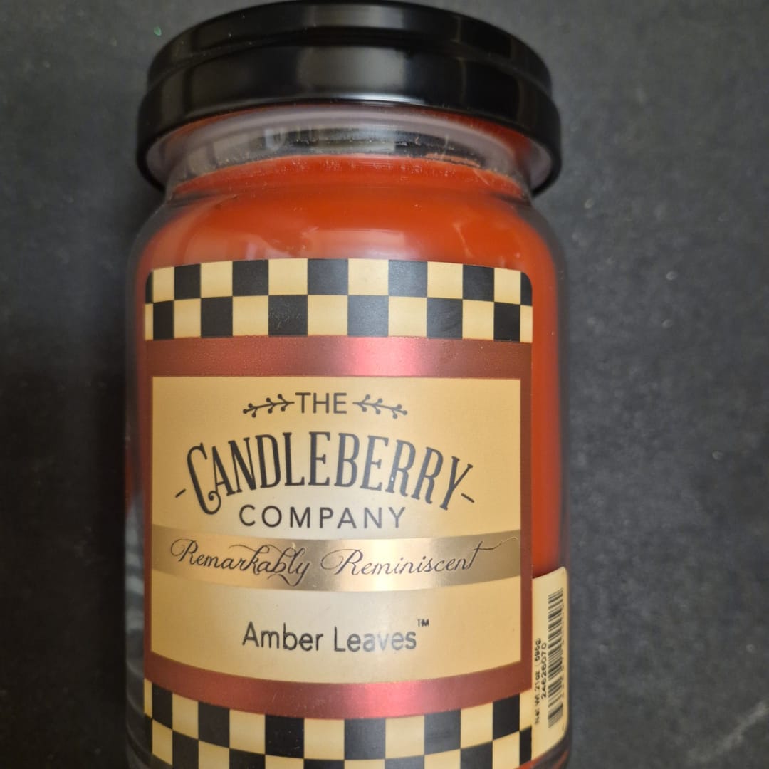 Amber jar candle with a black lid and labeled front