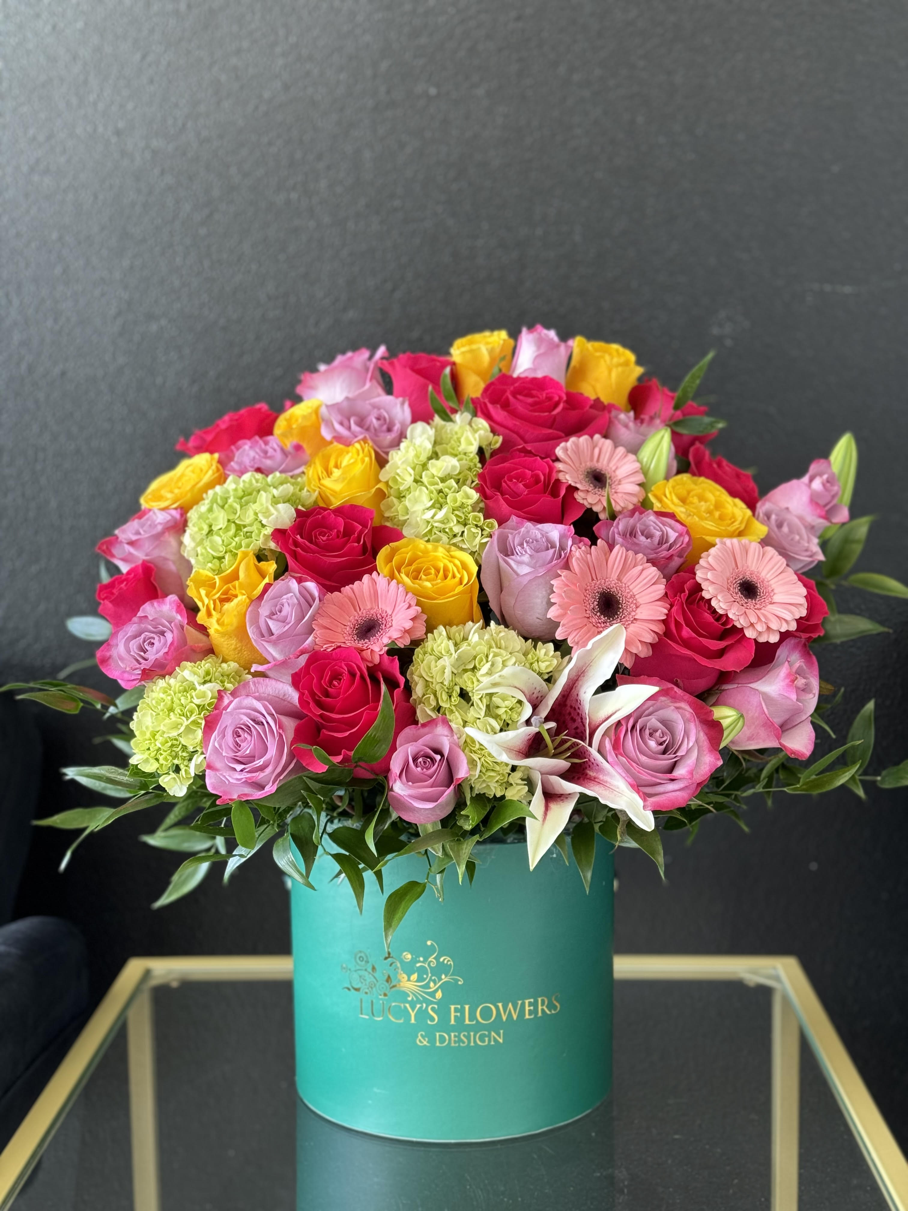 Sweet Spring  - Spring has sprung with this colorful arrangement. A stylish and unique arrangement designed in Lucy's signature emerald box, which holds a variety of fresh blooms, such as roses, lilies, hydrangeas and gerbera daises. Perfect for any event, such as birthday, anniversary, and especially Mother's Day!   Arrangement Includes: -Lucy's Signature Small Box -Fresh Cut Roses -Custom Message Card -Care Instructions  Disclaimer: Photos shown on our website are the  Deluxe or Premium version of the arrangement.