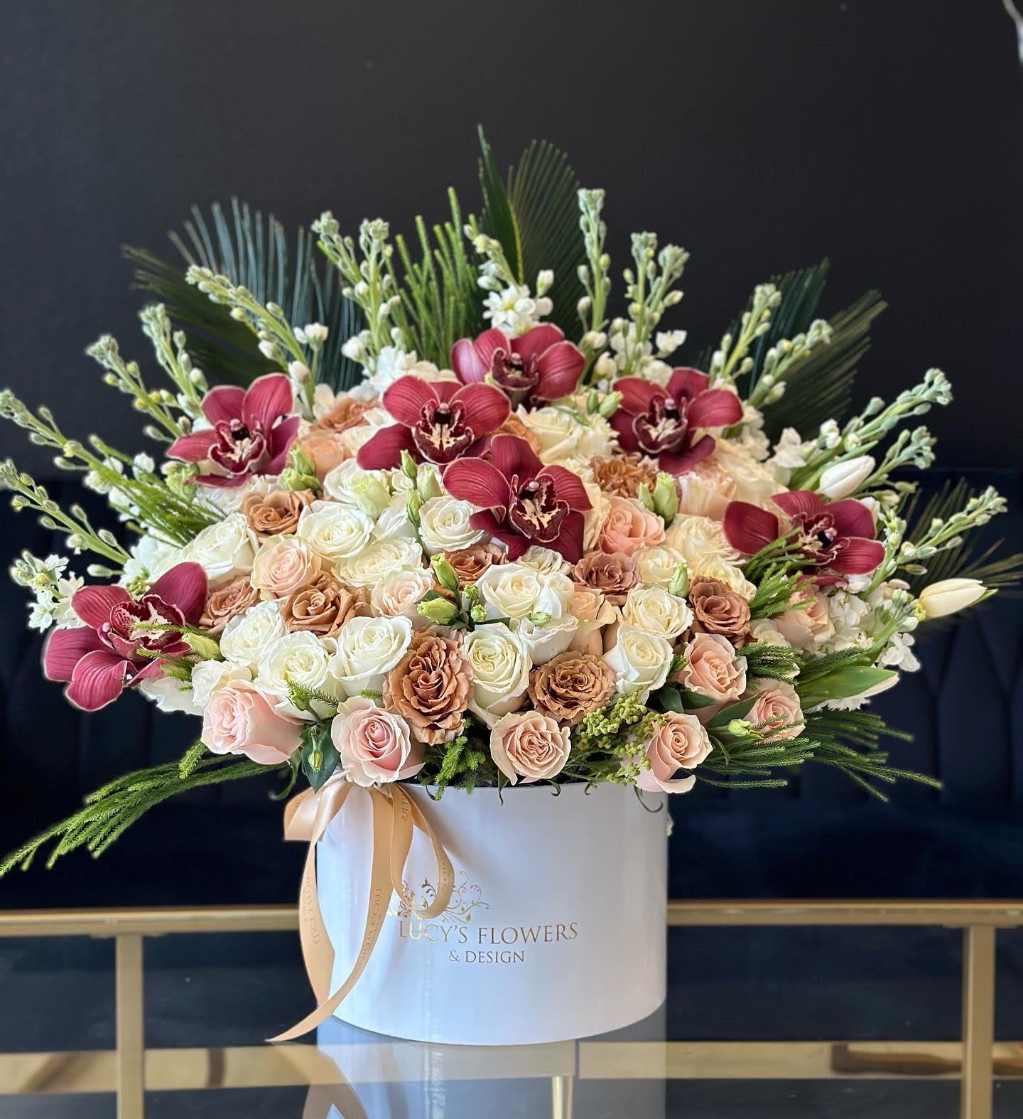 Large rose arrangement with burgundy orchids in a white hat box