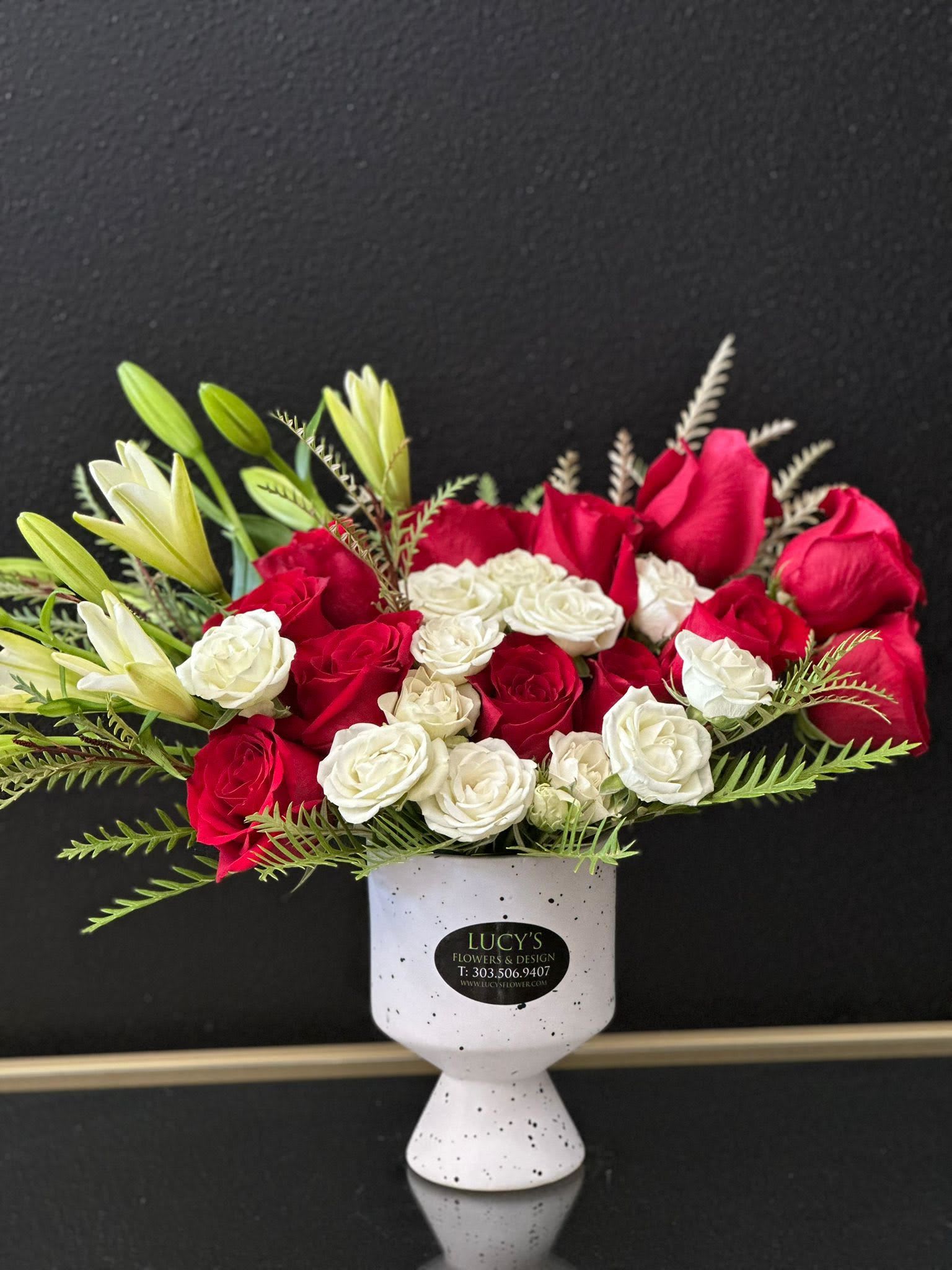 Sparks Of Romance - A beautifully crafted arrangement featuring the elegance of white lilies paired with the deep red beauty of roses. Arranged in a sleek white ceramic vase, this stunning bouquet exudes romance and sophistication. A perfect choice to celebrate love and create unforgettable moments.  Arrangement Includes: -Fresh Cut White &amp; Red Roses &amp; Other Blooms -White Ceramic Vase  -Custom Greeting Card -Care Instructions