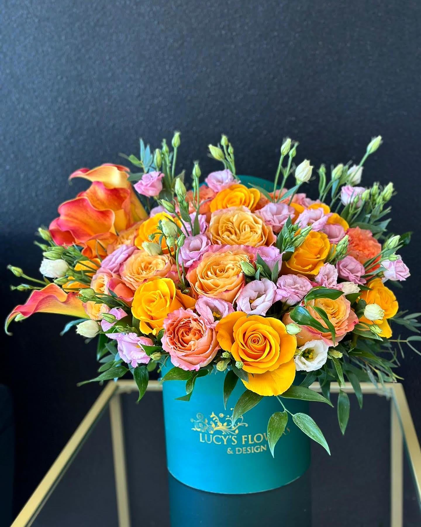 Bouquet of orange and pink roses with calla lilies in a turquoise box