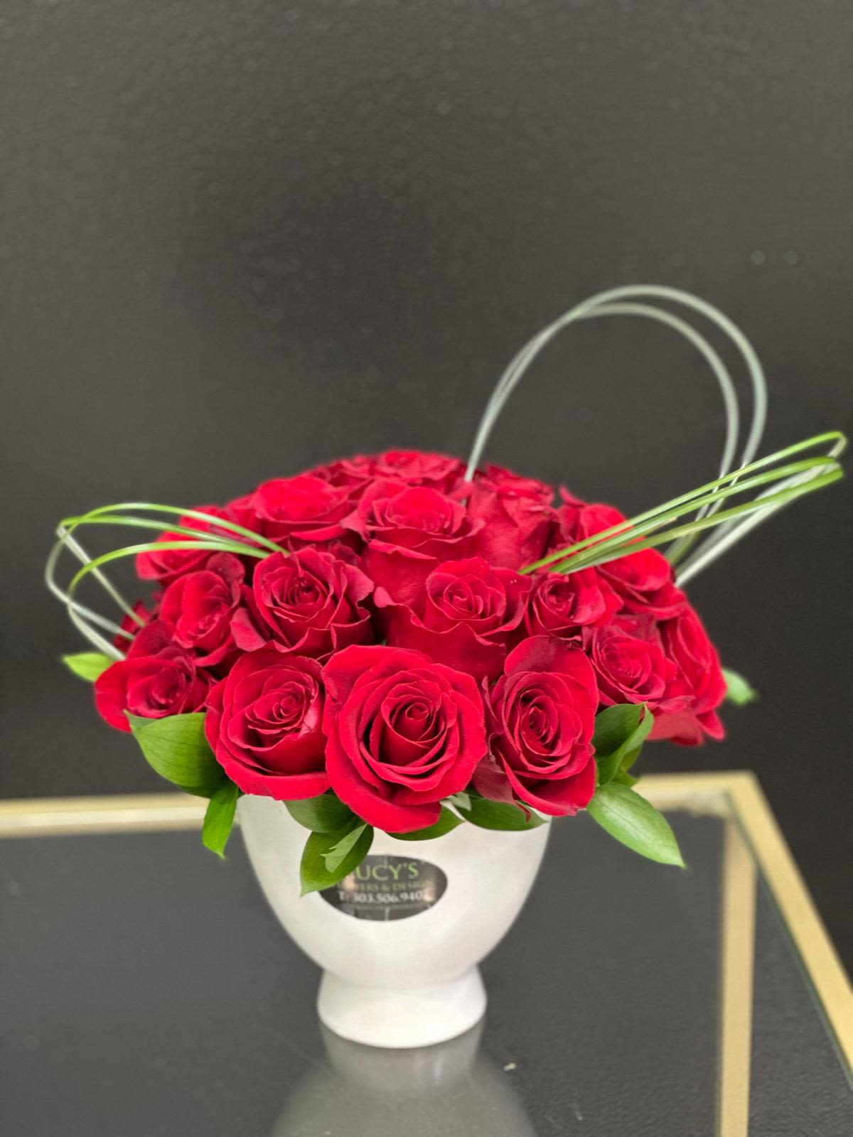 Spark of Love  - This modern arrangement showcases vibrant red roses arranged in a sleek white ceramic vase, complemented by fresh greenery for a contemporary touch. Simple yet striking, it’s the perfect expression of elegance and sophistication.  Arrangement Includes: -Fresh Cut Red Roses  -White Ceramic Vase -Custom Greeting Card -Care Instructions 