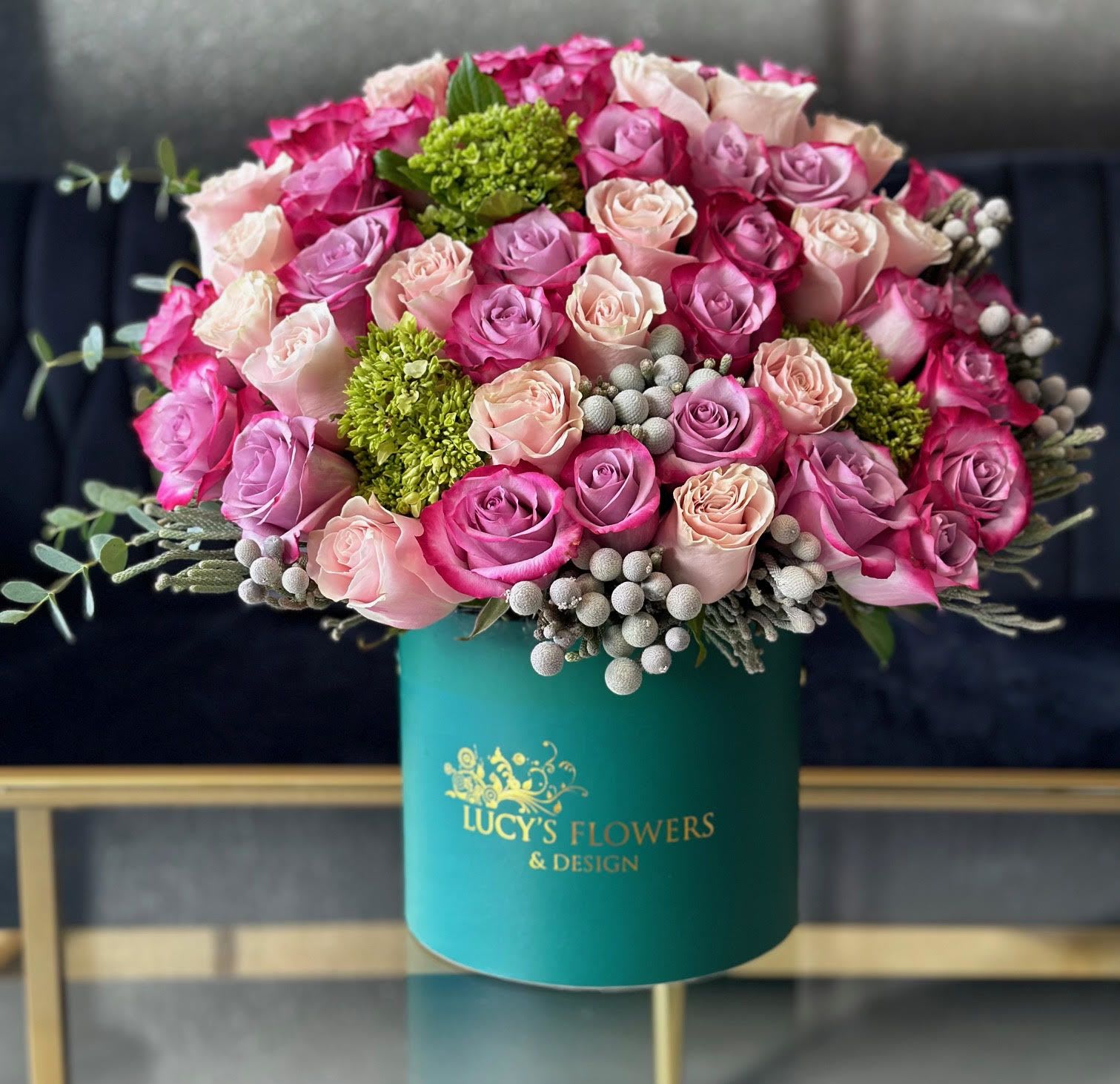 Home for The Holidays - A selection of pink and purple flowers come together in an eye-pleasing arrangement. This arrangement makes a great gift for any occasion, whether it's the holidays, anniversary, birthday or as a thinking of you present.  Arrangement Includes: -Fresh Cut Roses -Lucy's Signature Small Size Box -Custom Greeting Card -Care Instructions  Approximate Dimensions: 10''D x 10''H