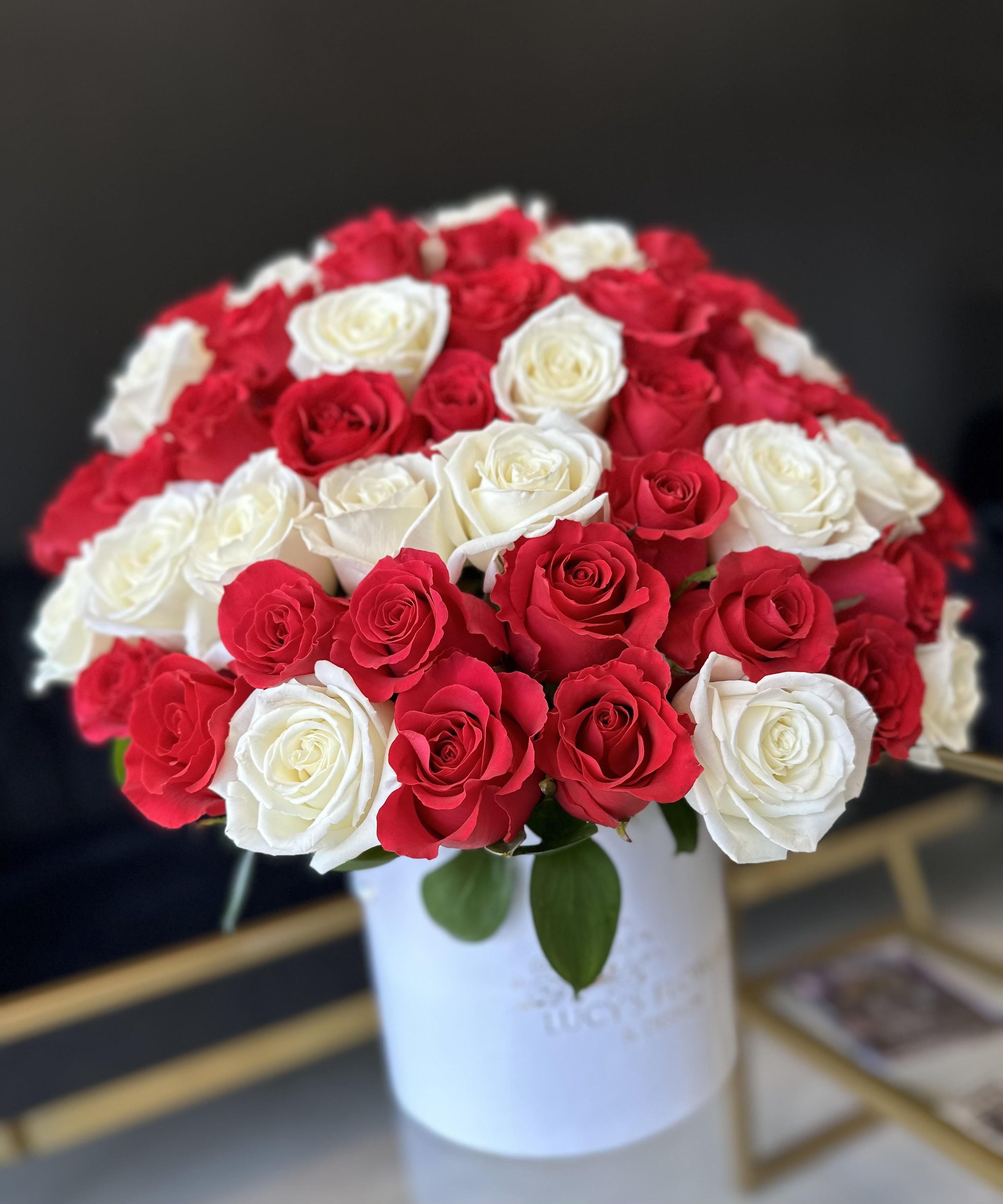 Bouquet of red and white roses in a white hatbox
