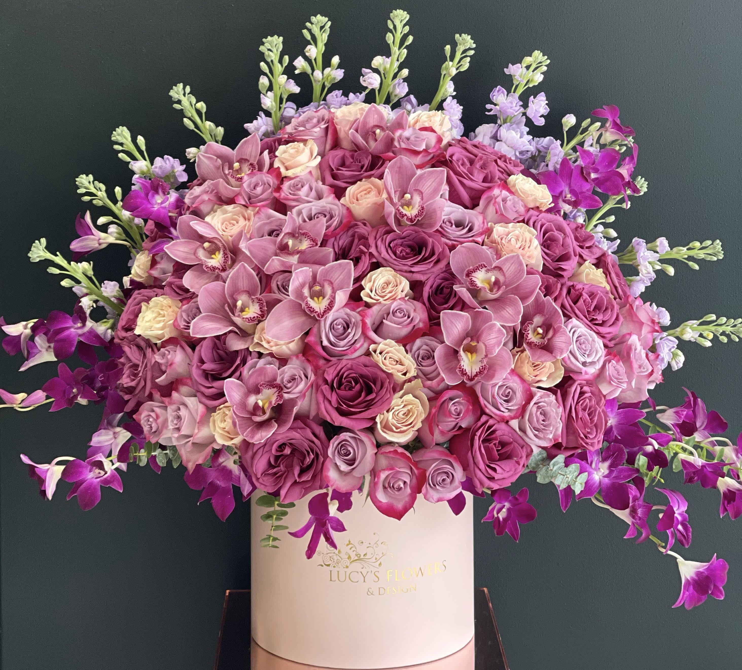 Pink and purple rose bouquet in a white hat box