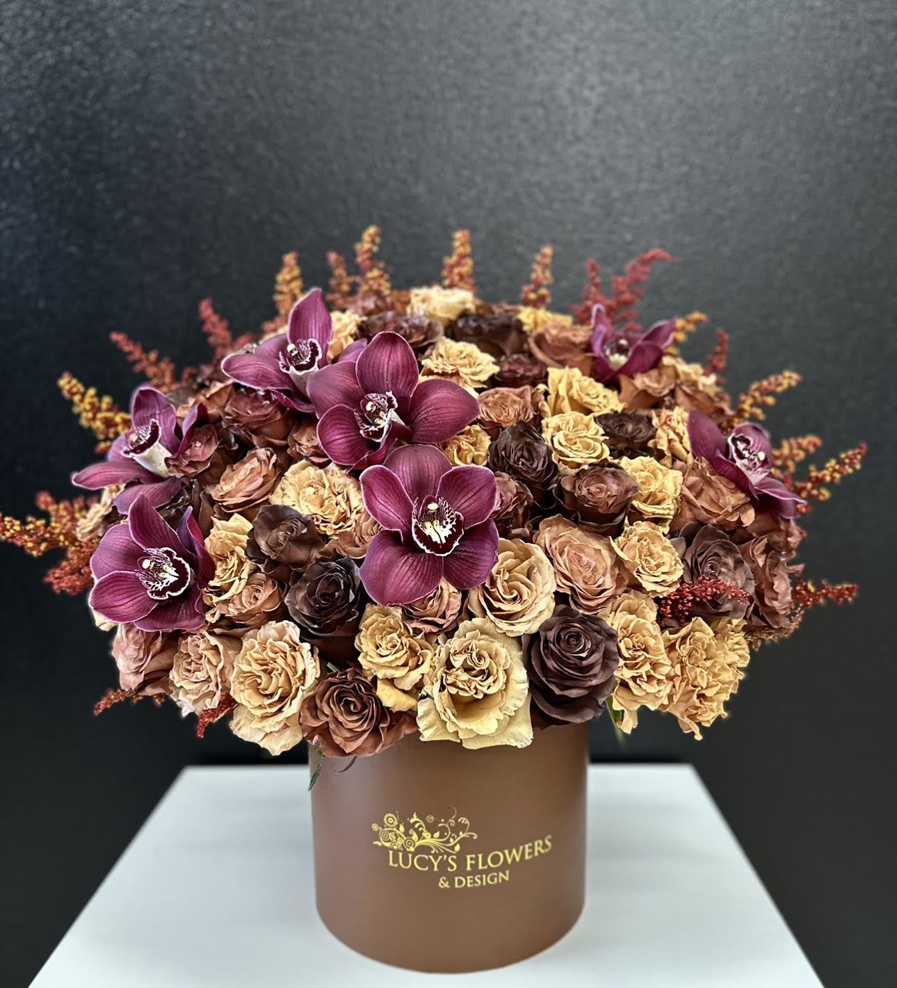Bouquet of purple orchids and dried roses in a brown box