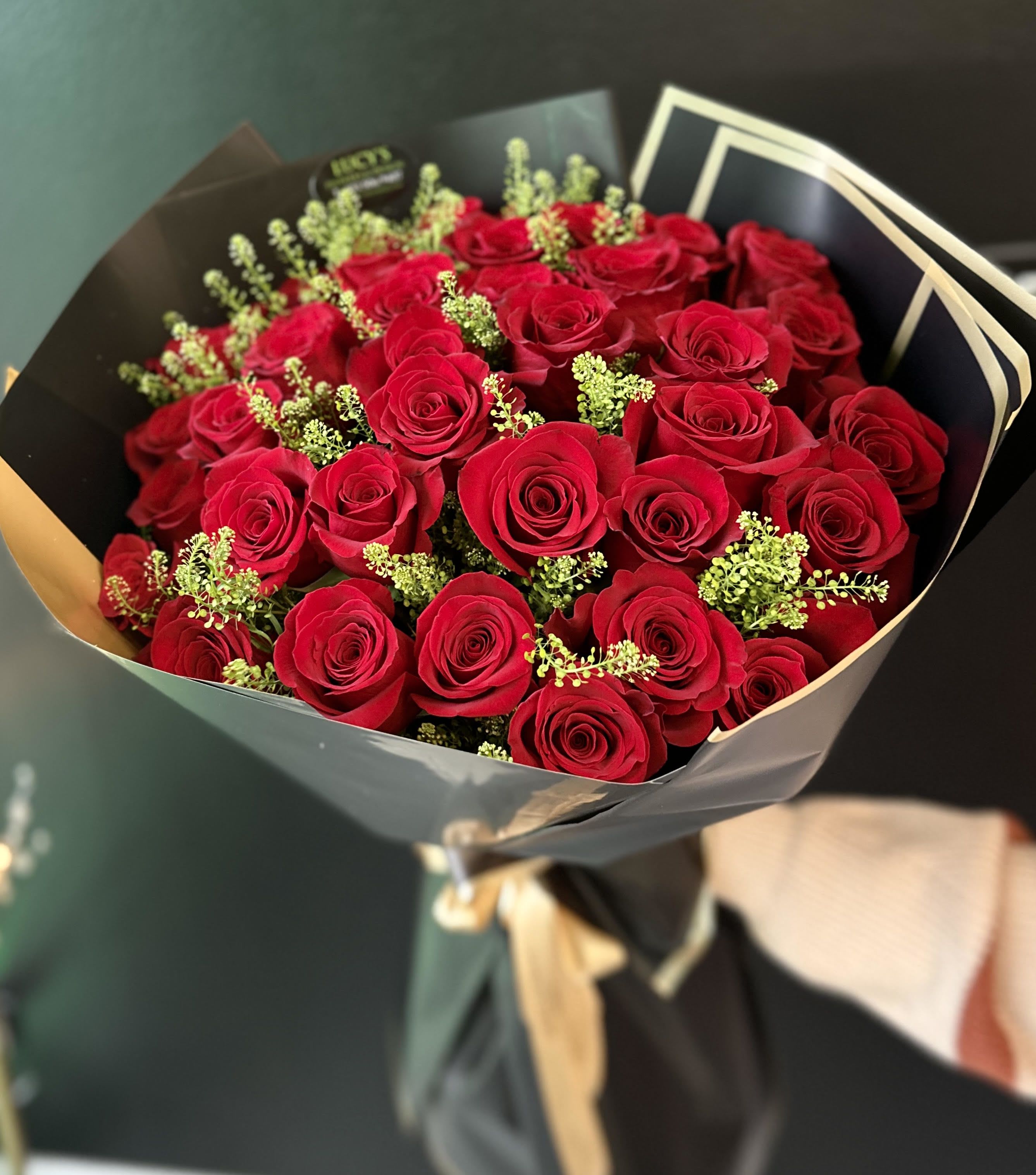Bouquet of red roses wrapped in black paper