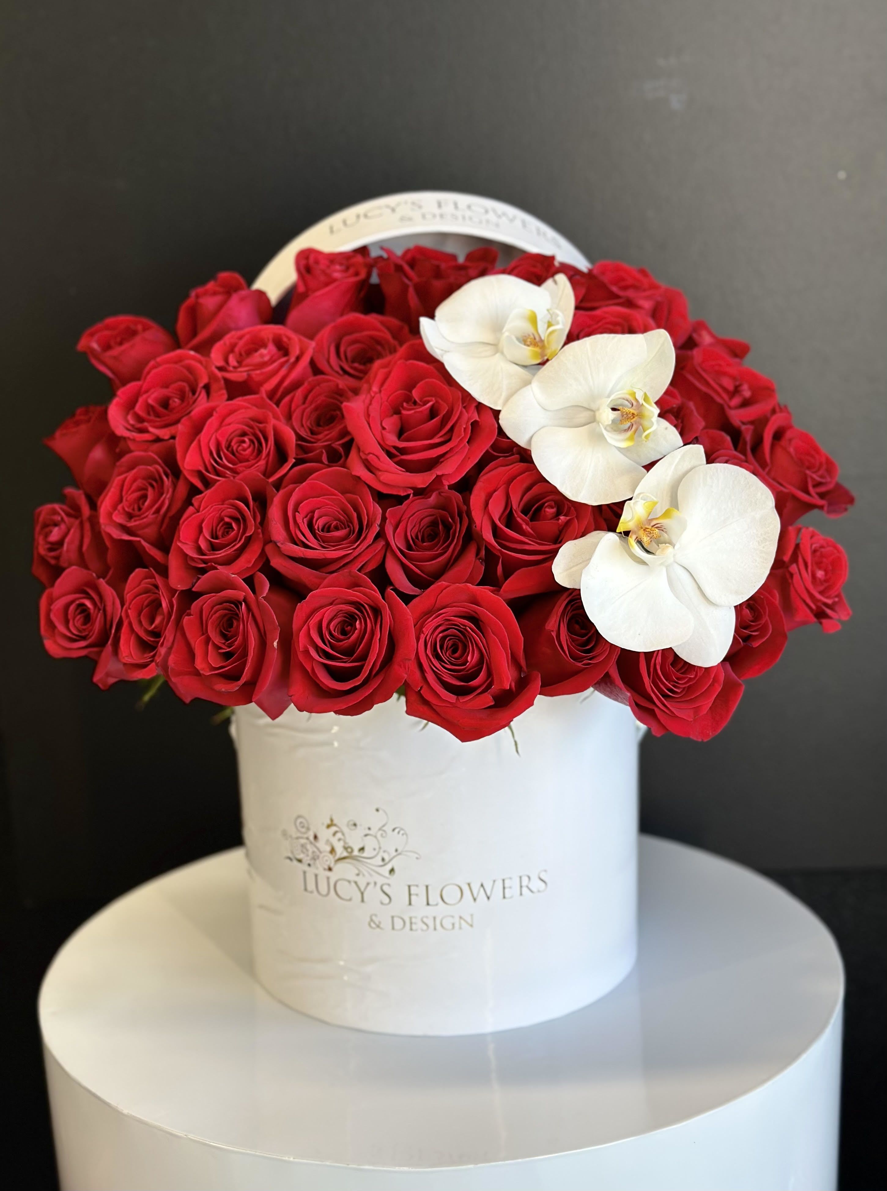 Truly Adored -  Capturing the essence of elegance, romance and passion with this beautiful box of classic red and white roses that are put together with  lots of effort to create a stunning arrangement... Truly Adored  is the romantic gift for Valentine's Day,  Anniversary or  just to say "I Love You."  Arrangement Includes: -Fresh cut red roses &amp; Phalaenopsis orchids  -Lucy's Flowers &amp; Design Signature box (20" Dia, x 17" H) -Custom Greeting Card -Care Instructions