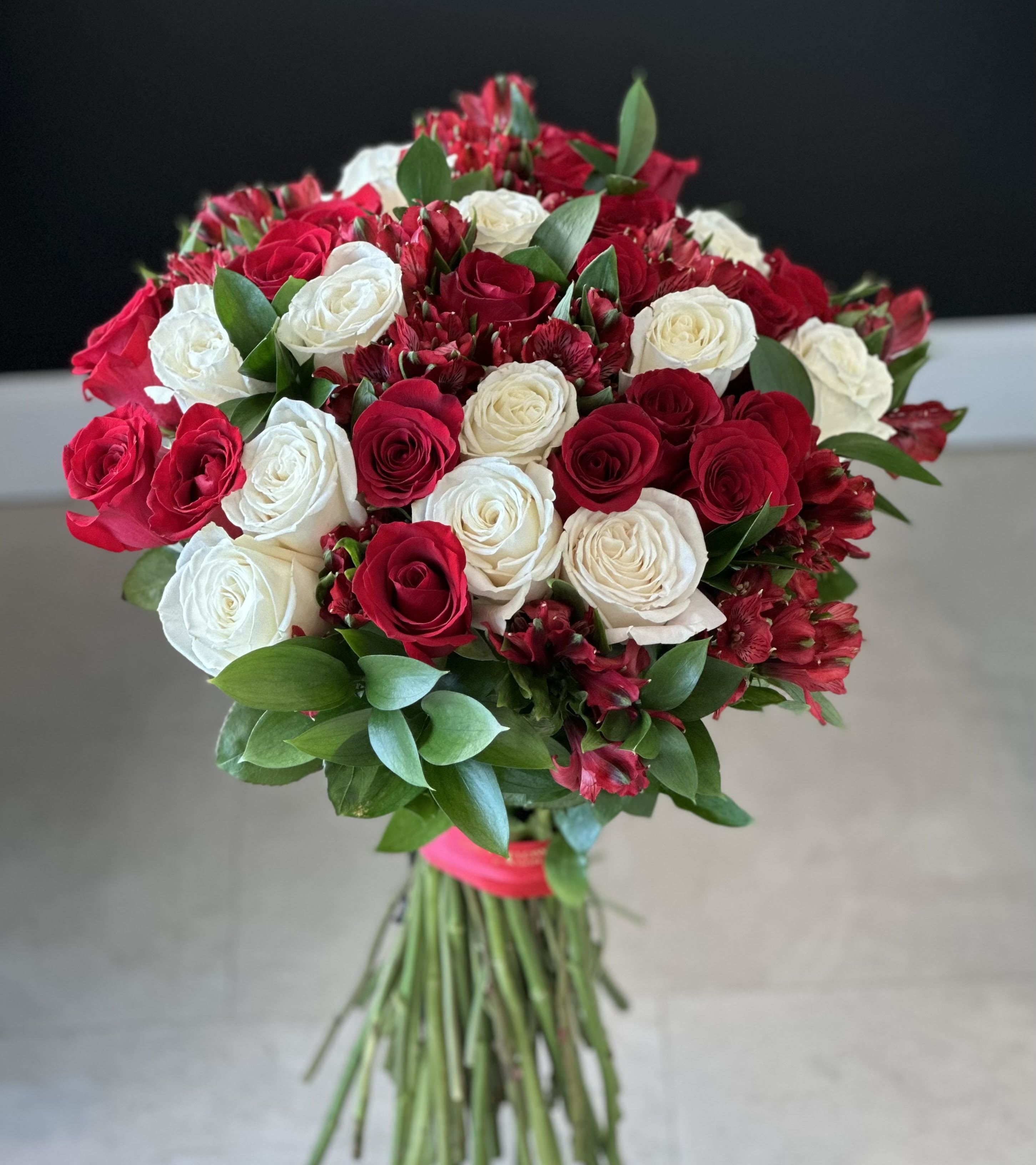 Bouquet of red and white roses with greenery