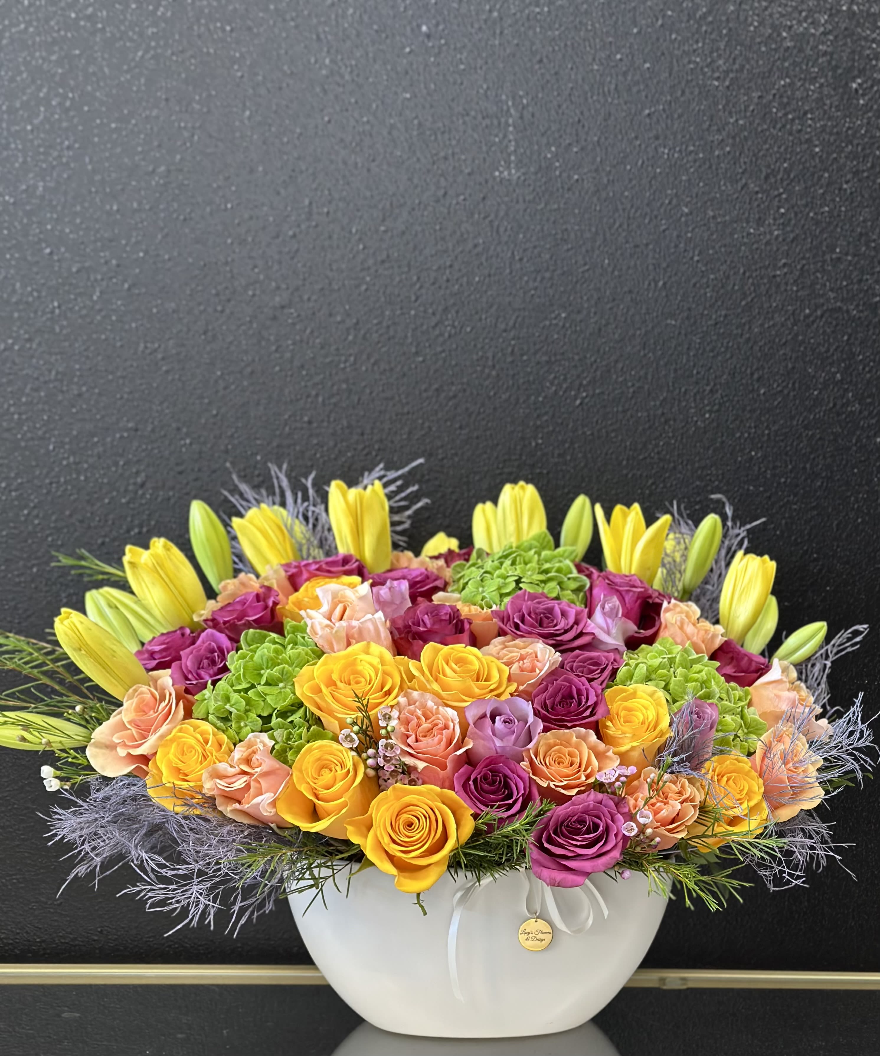 Bright mixed flower arrangement in a white bowl vase
