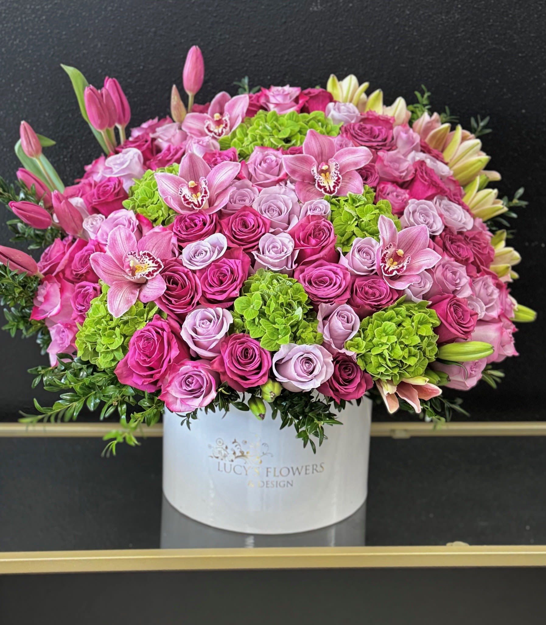 Large pink and lavender flower arrangement in a white box