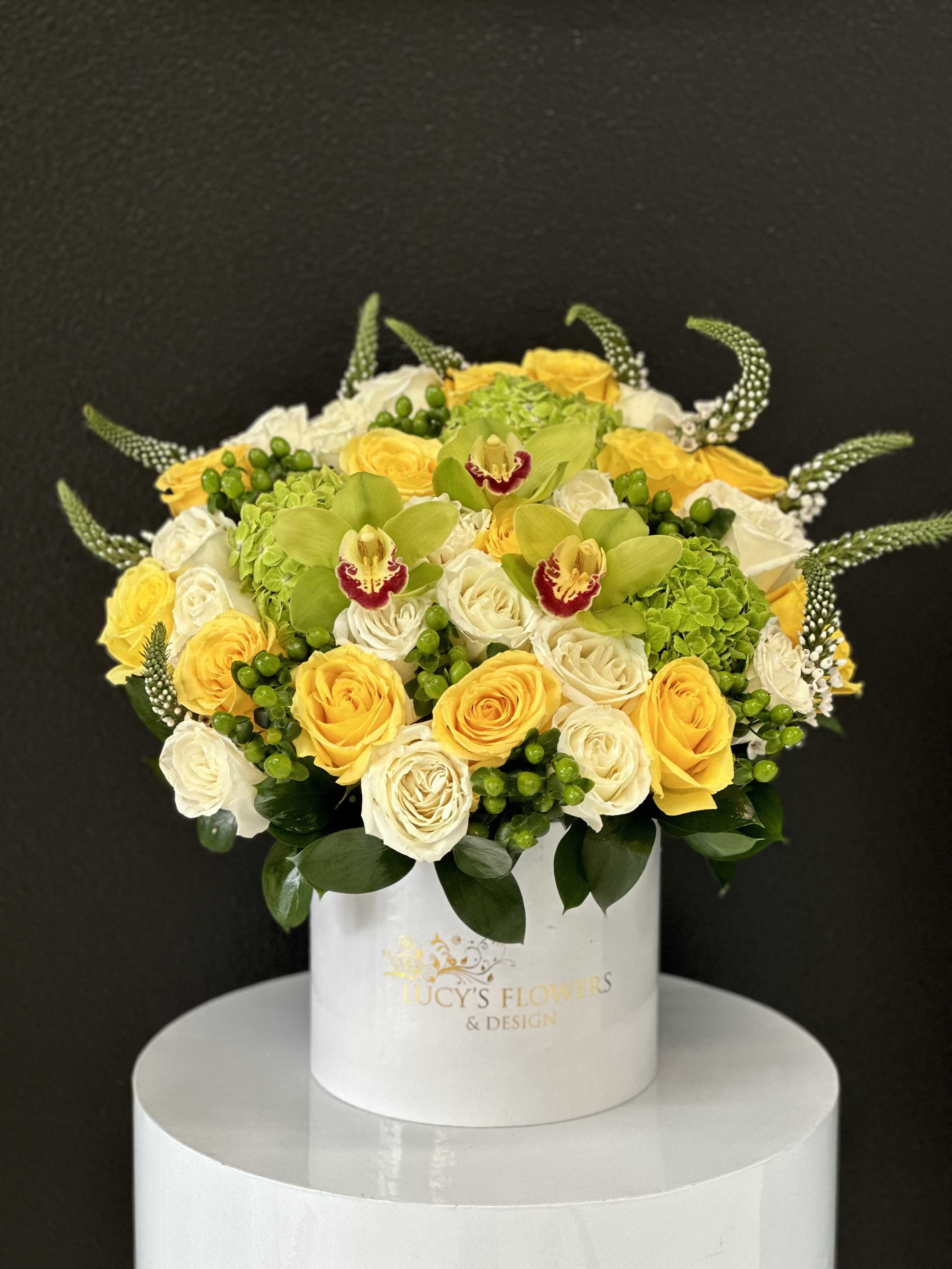 Round bouquet of yellow and white roses in a white hat box