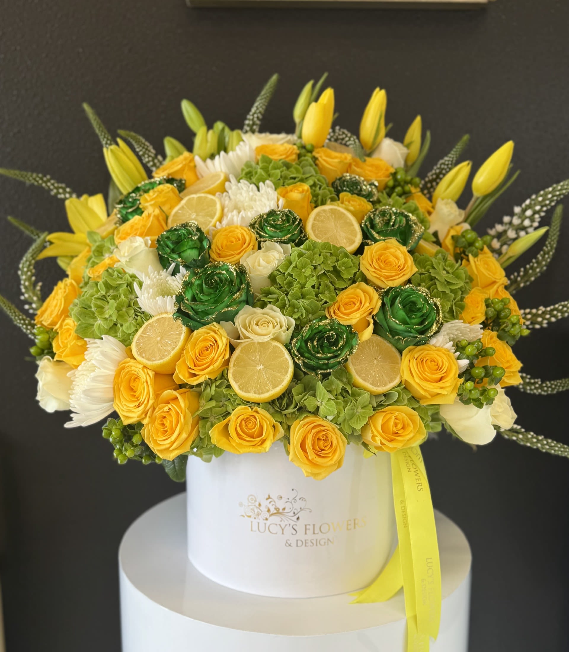 Citrus Muse - A bold blend of freshness and form-Citrus Muse is designed to inspire. With sunlit florals in yellow and green tones, accented by real lemon and lime, this arrangement delivers a refreshing twist on modern elegance. Presented in our signature large white box, it's where creativity meets clean, summer beauty...  Arrangement Includes: -Fresh Cut Roses, Hydrangeas, Tulips, Lemons &amp; Limes -Lucy's Signature Large Size Box -Custom Greeting Card -Care Instructions 