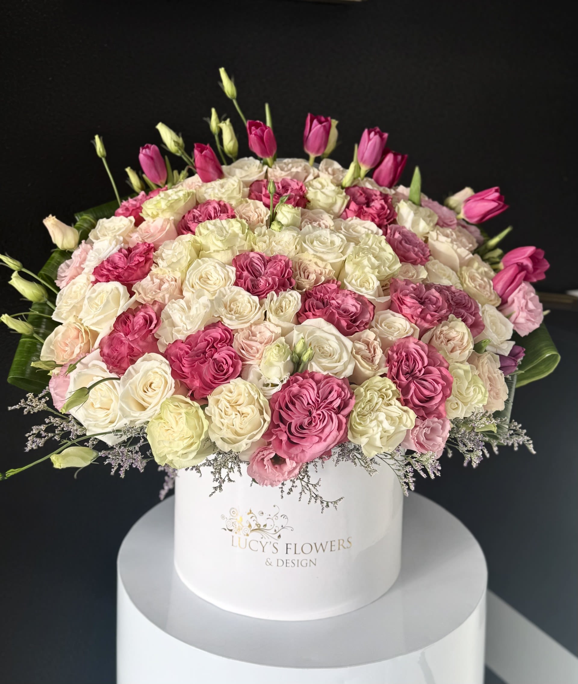 The Garden Rose Box - For romance, friendship or just to show that you care, this blushing beauty of a bouquet will lend a touch of glamour to any room. Featuring a medley of gentle blossoms such as garden roses, tulips and other blooms–  designed in a signature white box– it’s a truly gorgeous gift.  Arrangement Includes: -Fresh Cut Garden Roses, Tulips, Lisianthuses &amp; Other Blooms -Lucy's Signature Large Size Box -Custom Greeting Card -Care Instructions 