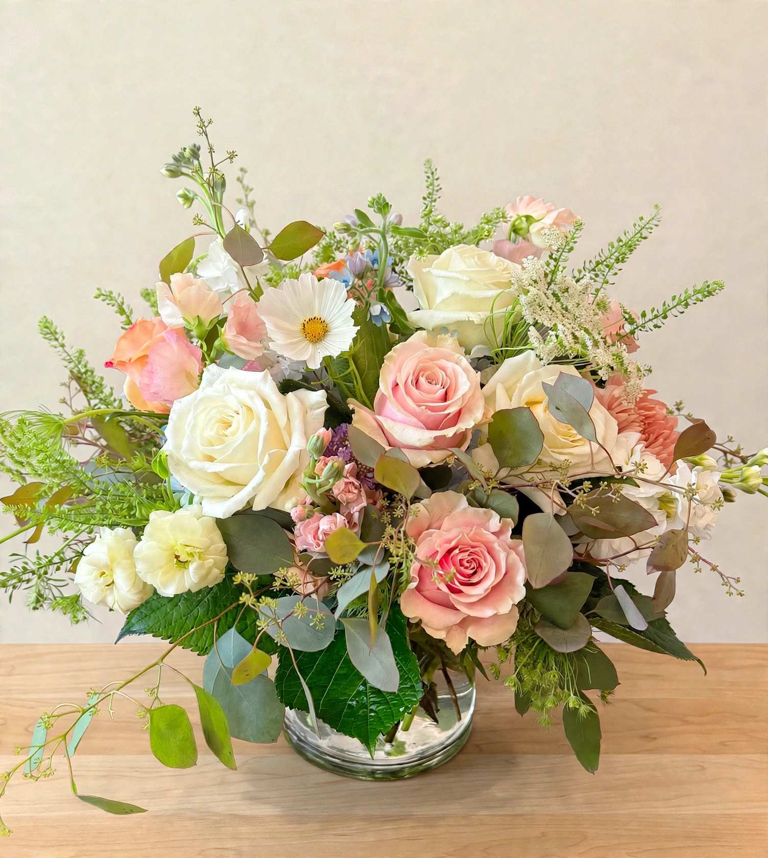 Pink and white rose bouquet in a clear glass vase