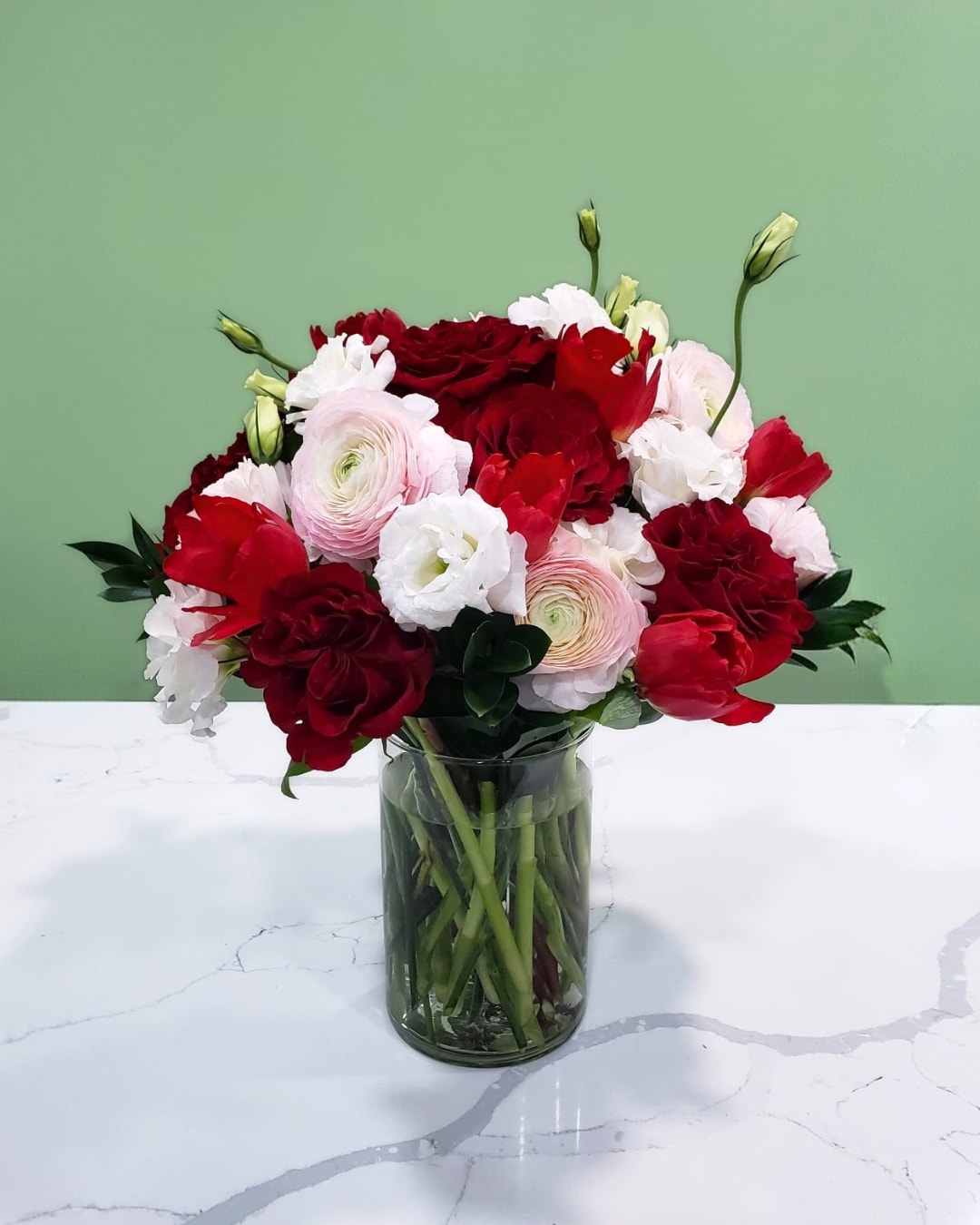 Bouquet of red and white flowers in a clear glass vase