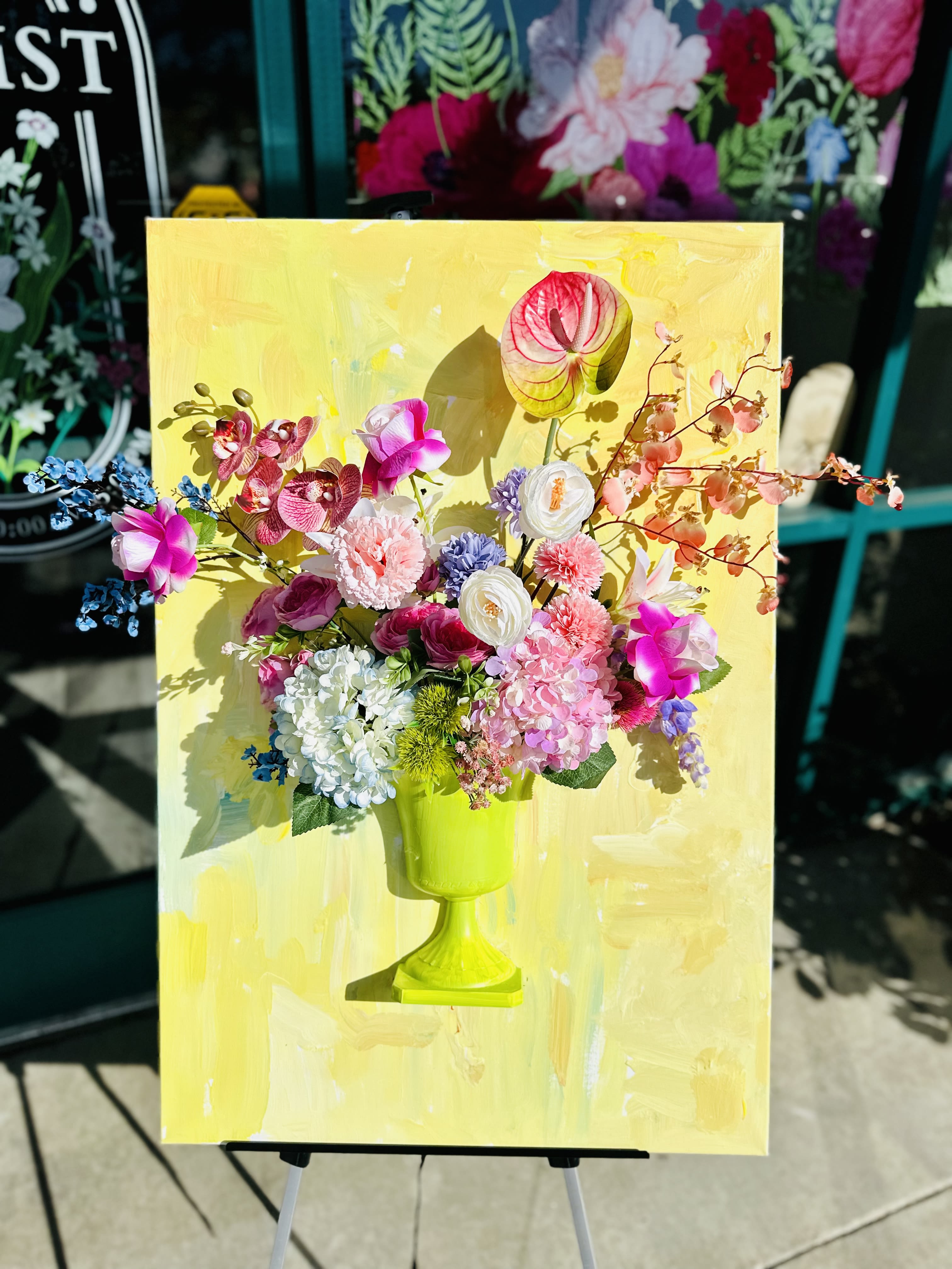 Colorful floral arrangement in a lime green vase on a yellow canvas