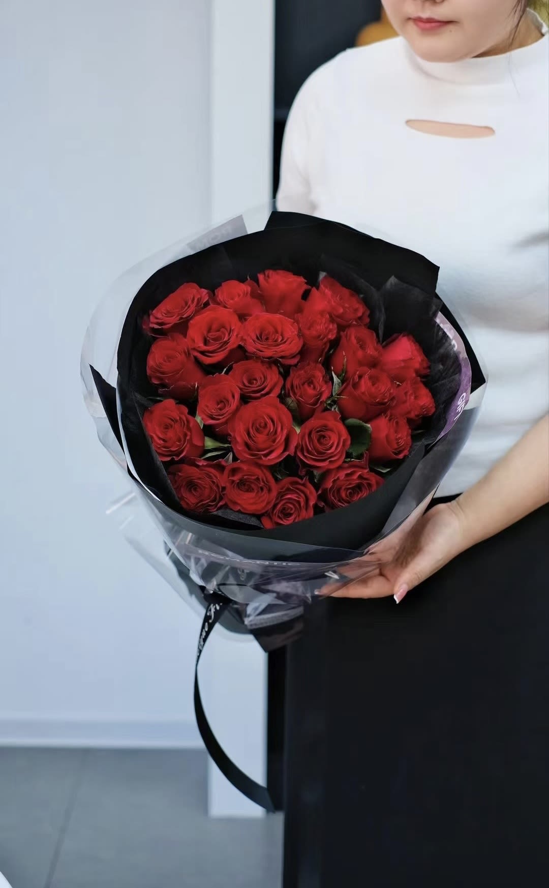 Bouquet of red roses wrapped in black paper